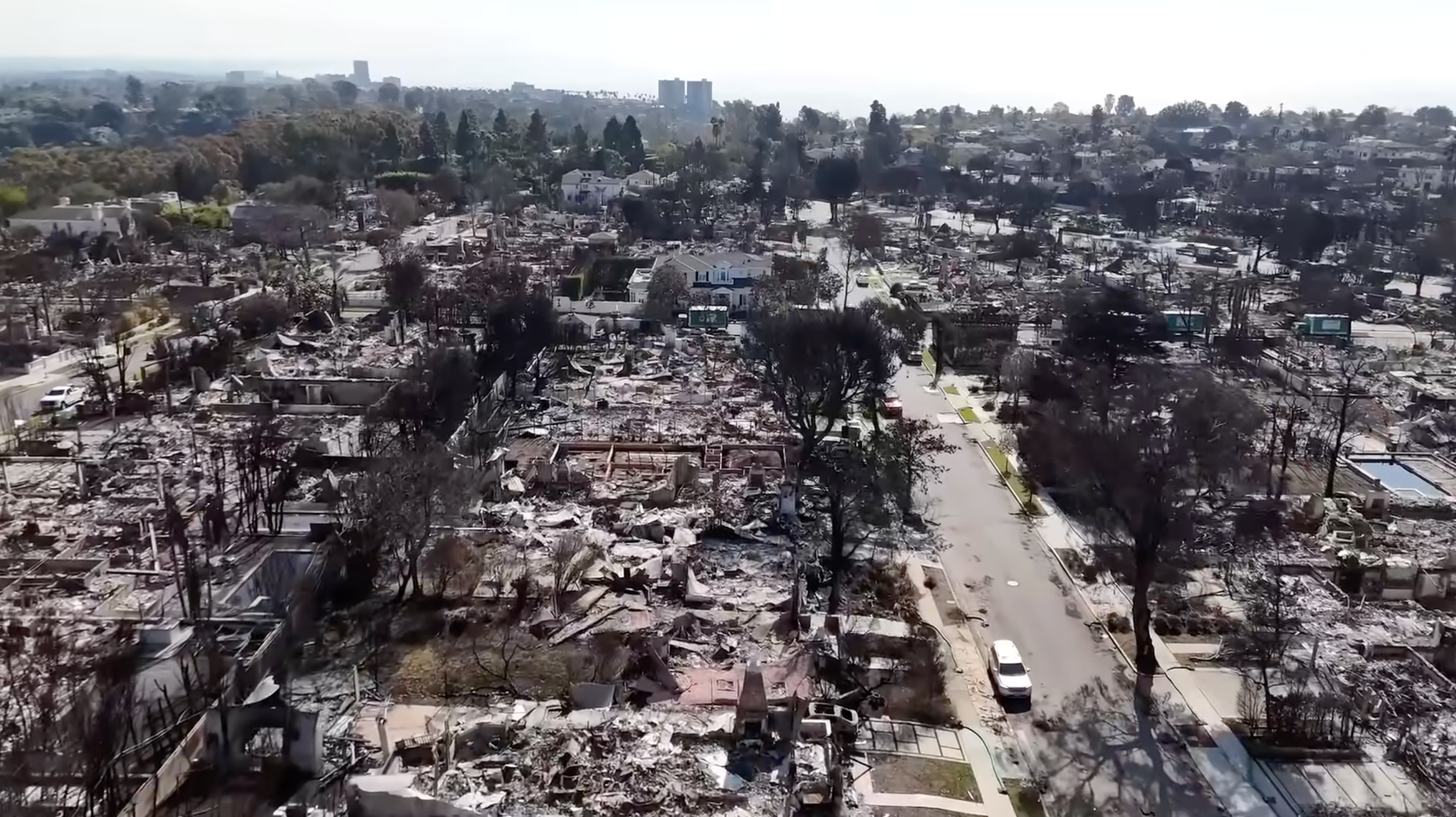 Aerial view of a neighborhood with widespread destruction and debris from a fire or disaster.