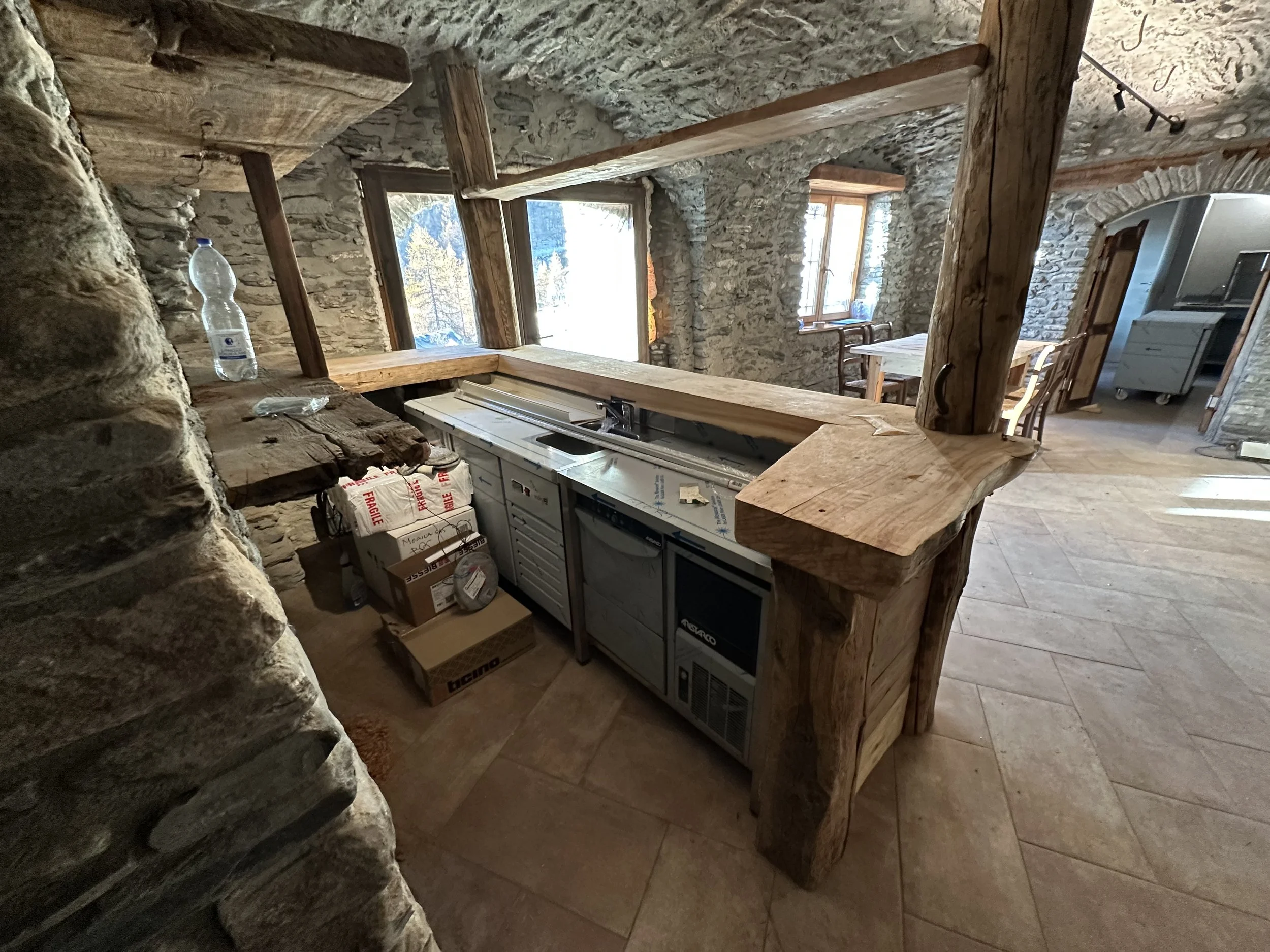 Cucina rustica con pareti in pietra e mobili in legno.