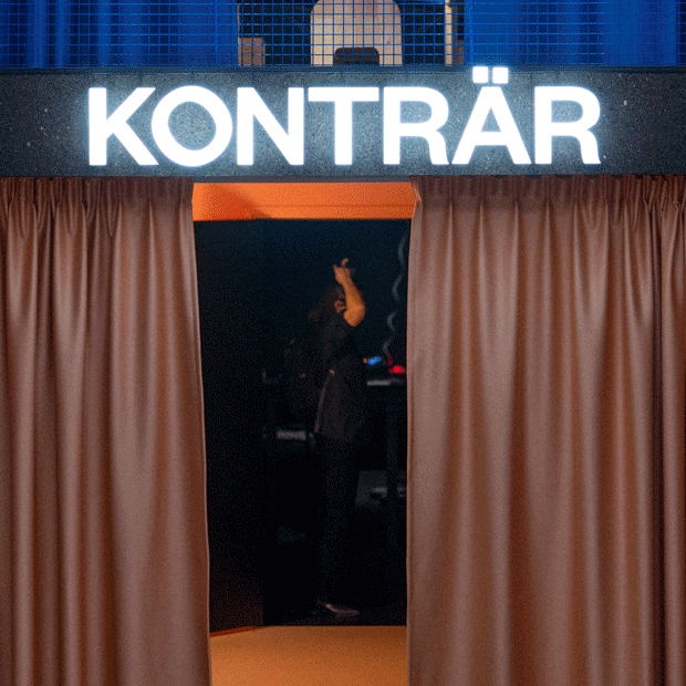 Entrance with brown curtains and a bright illuminated sign that reads 'KONTRÄR'