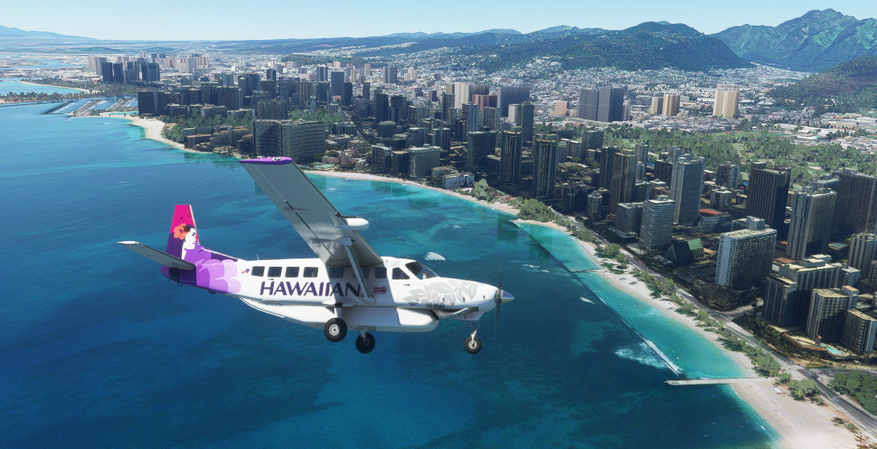 A small Hawaiian Air floatplane flying over a city coastline with high-rise buildings and mountainous terrain in the background.