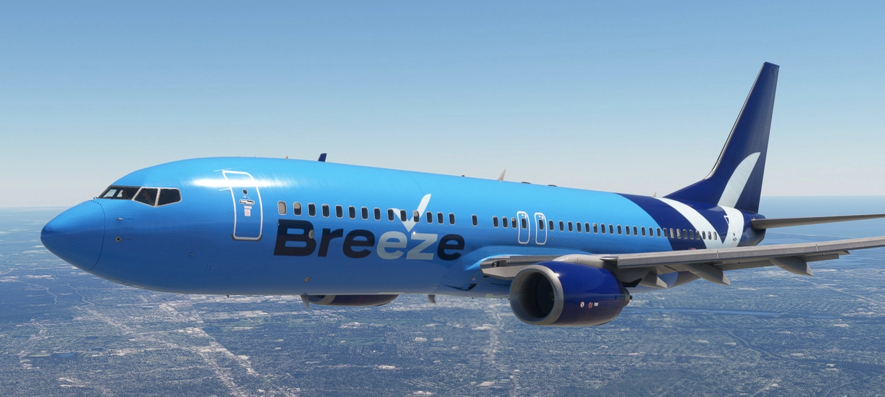 Blue Breeze airplane flying above the land with a clear sky.