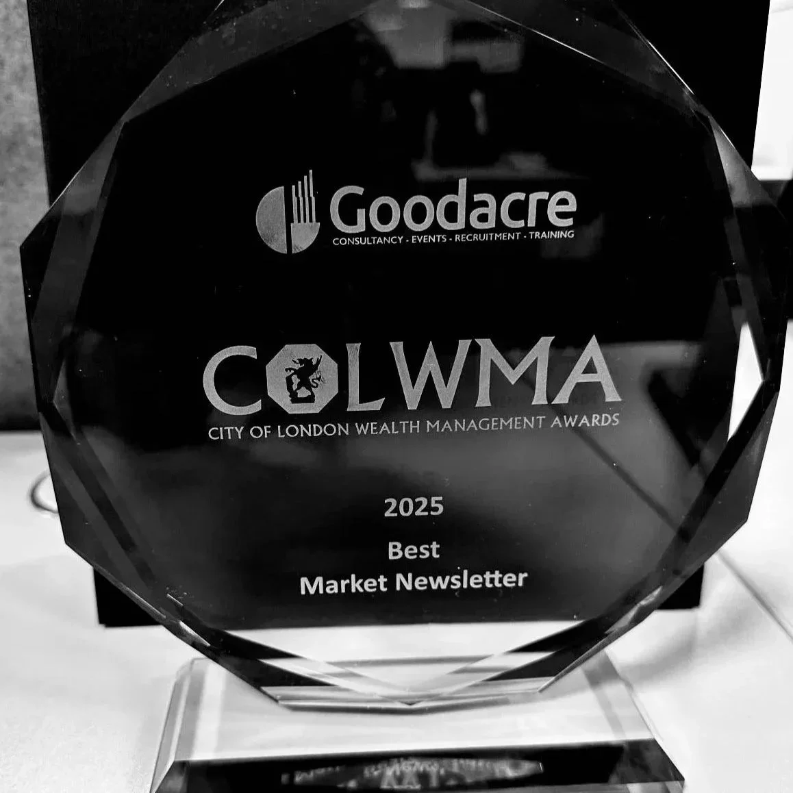 A crystal award with the logos of Goodacre and Colwma, inscribed with '2025, Best Market Newsletter, City of London Wealth Management Awards.'
