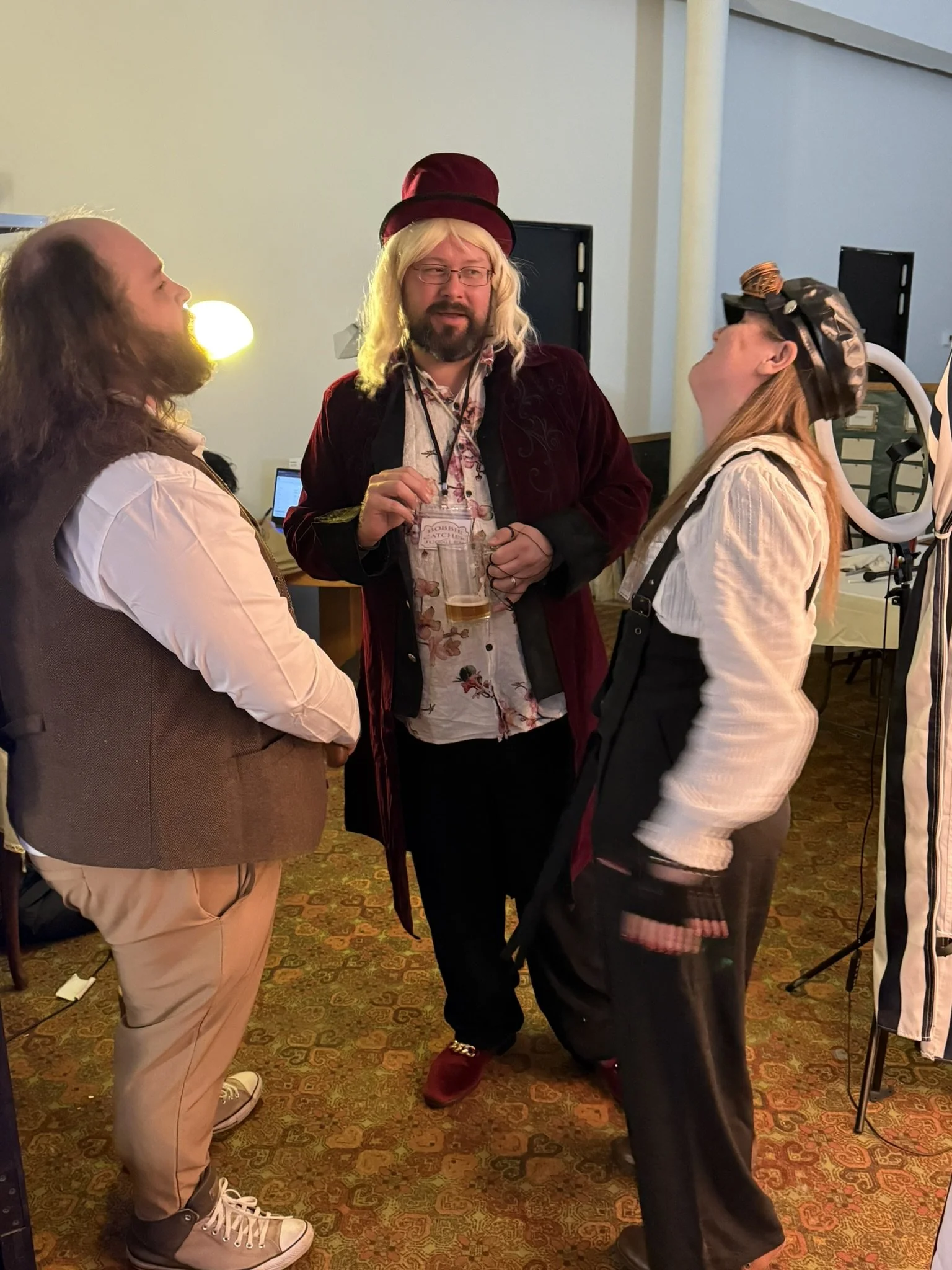 The juggle, stage hand, and talent scout are all dressed in costumes engaging in conversation at the Murder at the Circus event.