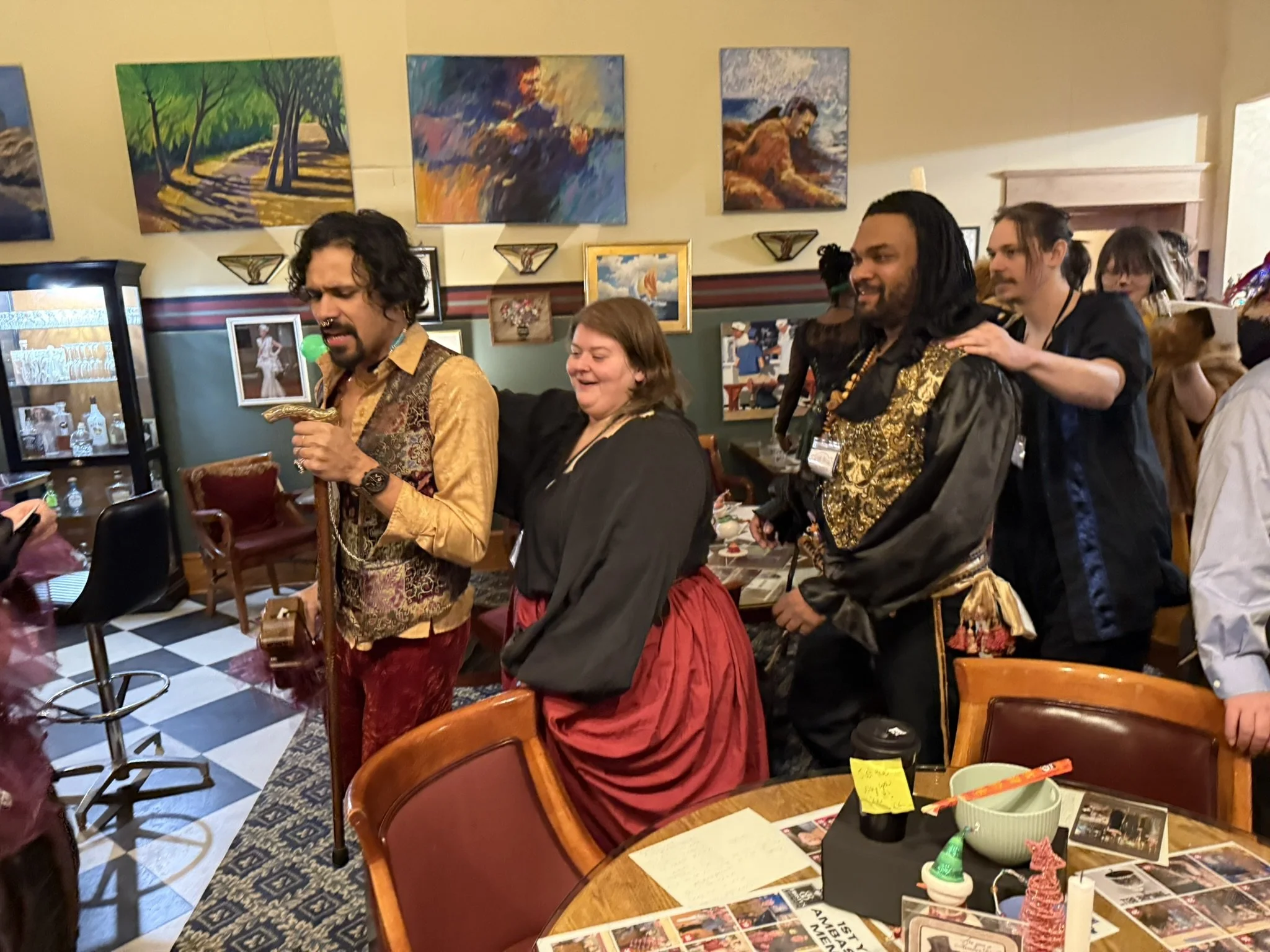 The escape artist of the Murder at the Circus Mystery Party leads a conga line through Frosty's Spirits and Social Club. Many fellow circus patrons, staff, & performers are following along with the dance. 