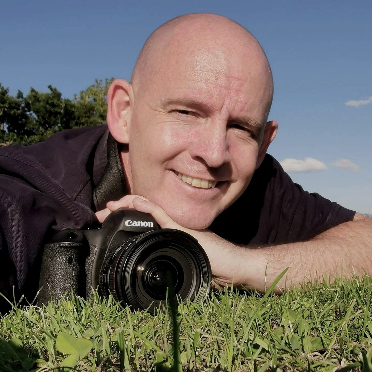 Neil with his trusty Canon Camera lying on the grass on a glorious Summer's Day