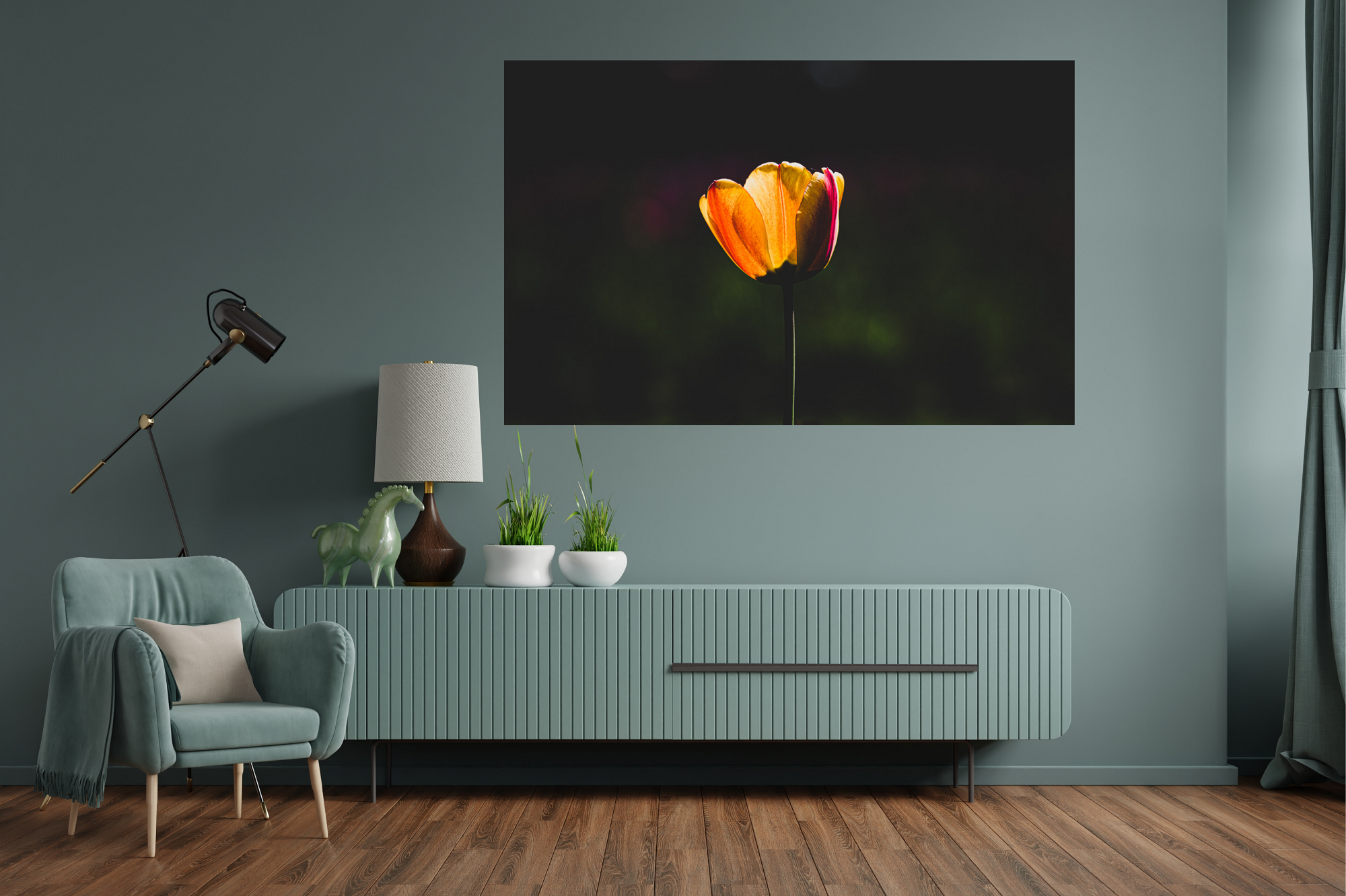 Living room with a light green sideboard, a light green armchair with a beige pillow, a floor lamp, a table lamp, and decorative plants. A large floral photograph of an orange and pink tulip on a black background hangs on the wall.