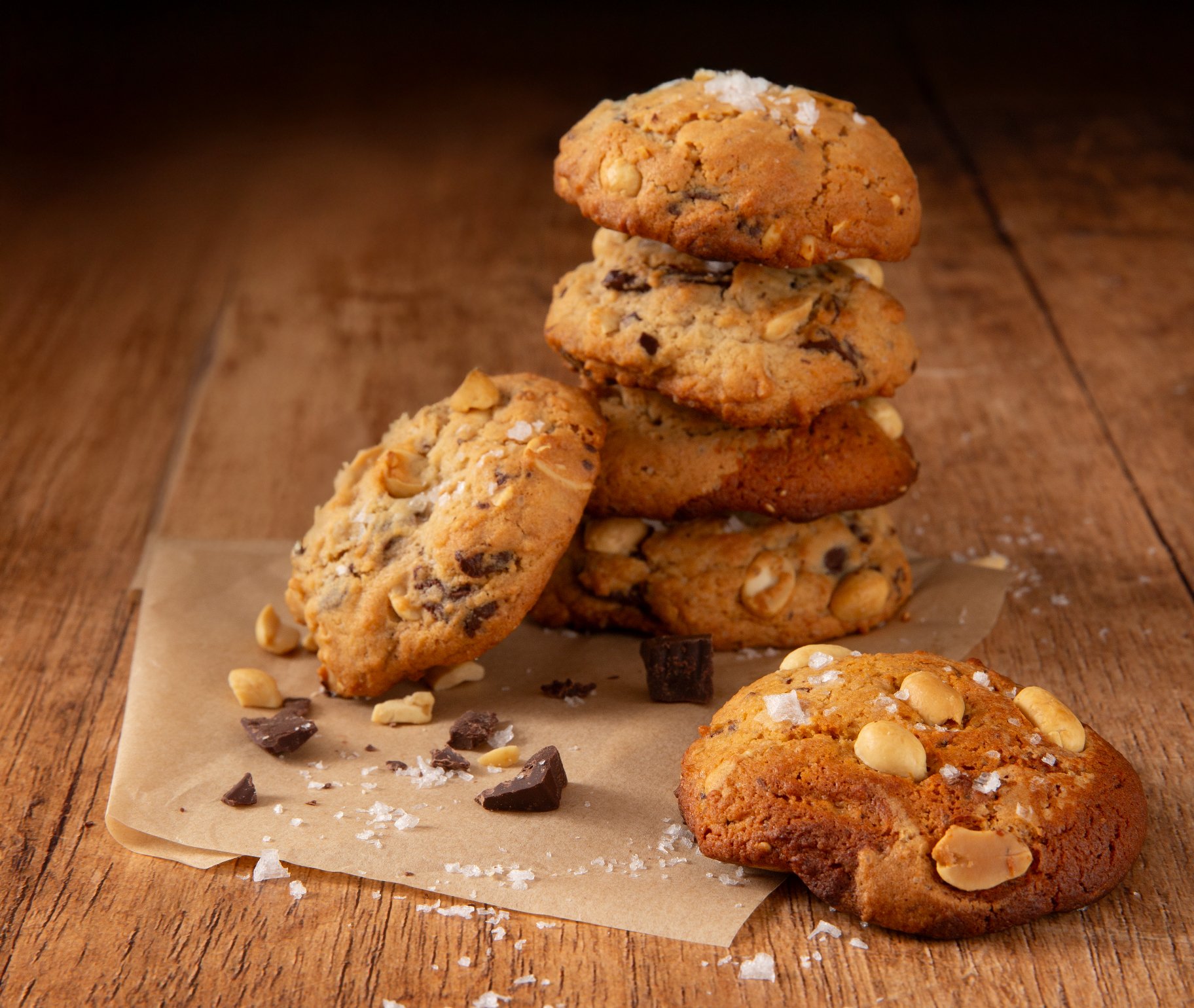 Shooting photo de cookie au flocon de sel, empilés en forme de tour sur une feuille de papier kraft, sur une table en bois.