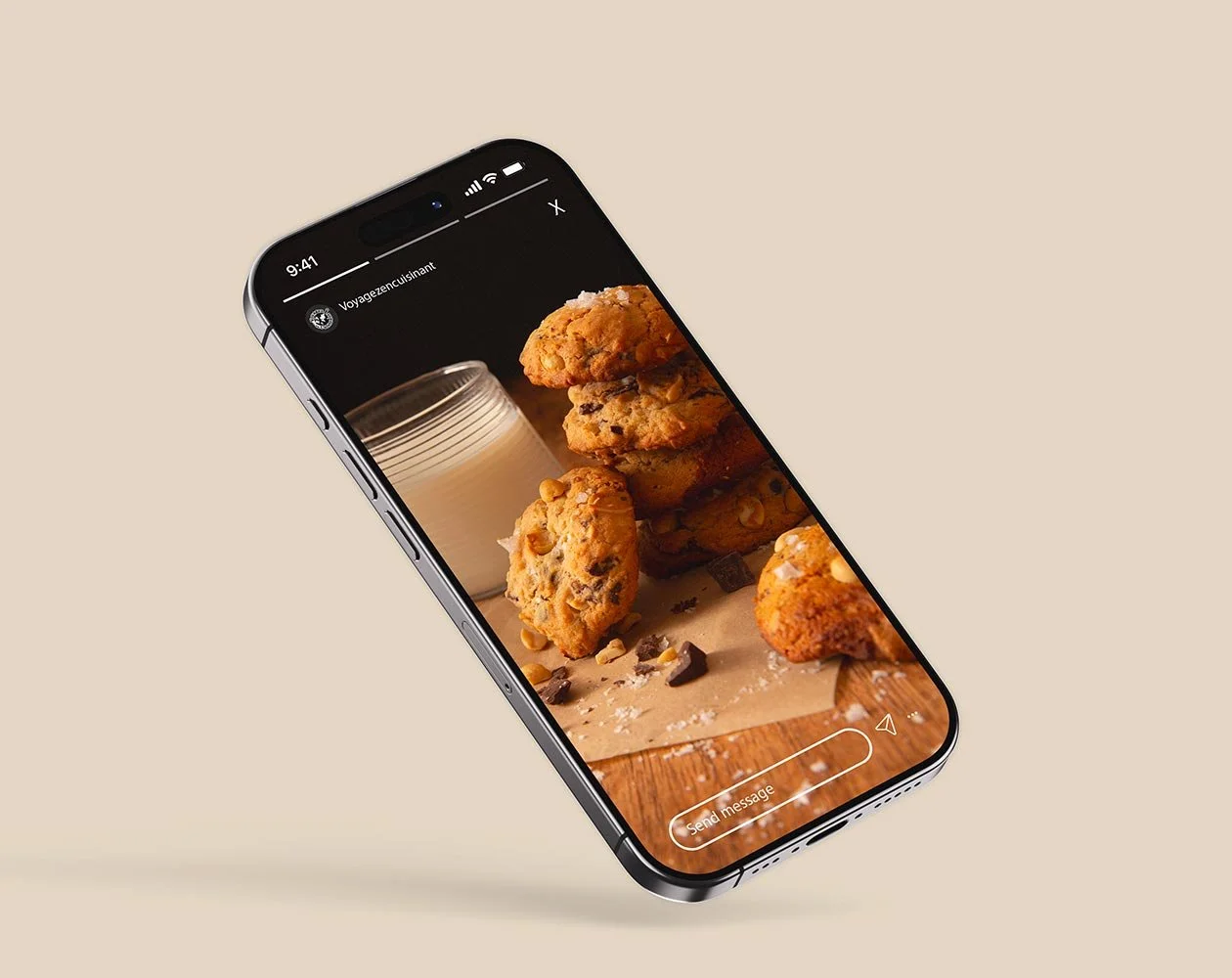 Un smartphone affichant une photo d'une tarte aux fraises garnie de cookies, aux pépites de chocolat, empilés sur un plan de travail en bois.