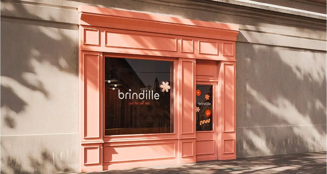 Vitrine d'une boutique rose pour enfants appelée 'brindille' avec des décorations florales