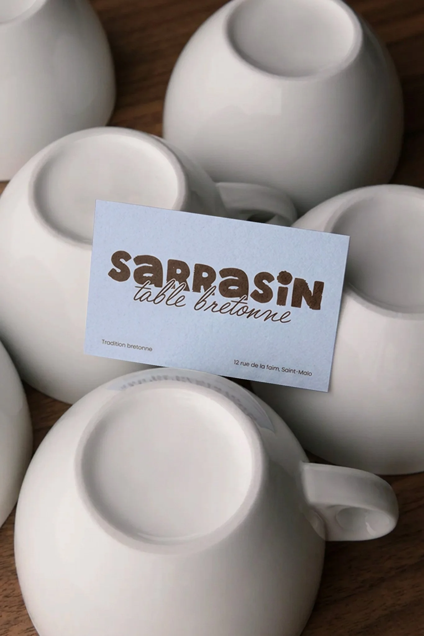 Identité visuelle de Sarrasin, avec une carte de visite personnalisée mise en scène sur des bolées en céramique, dans un univers doux et naturel.