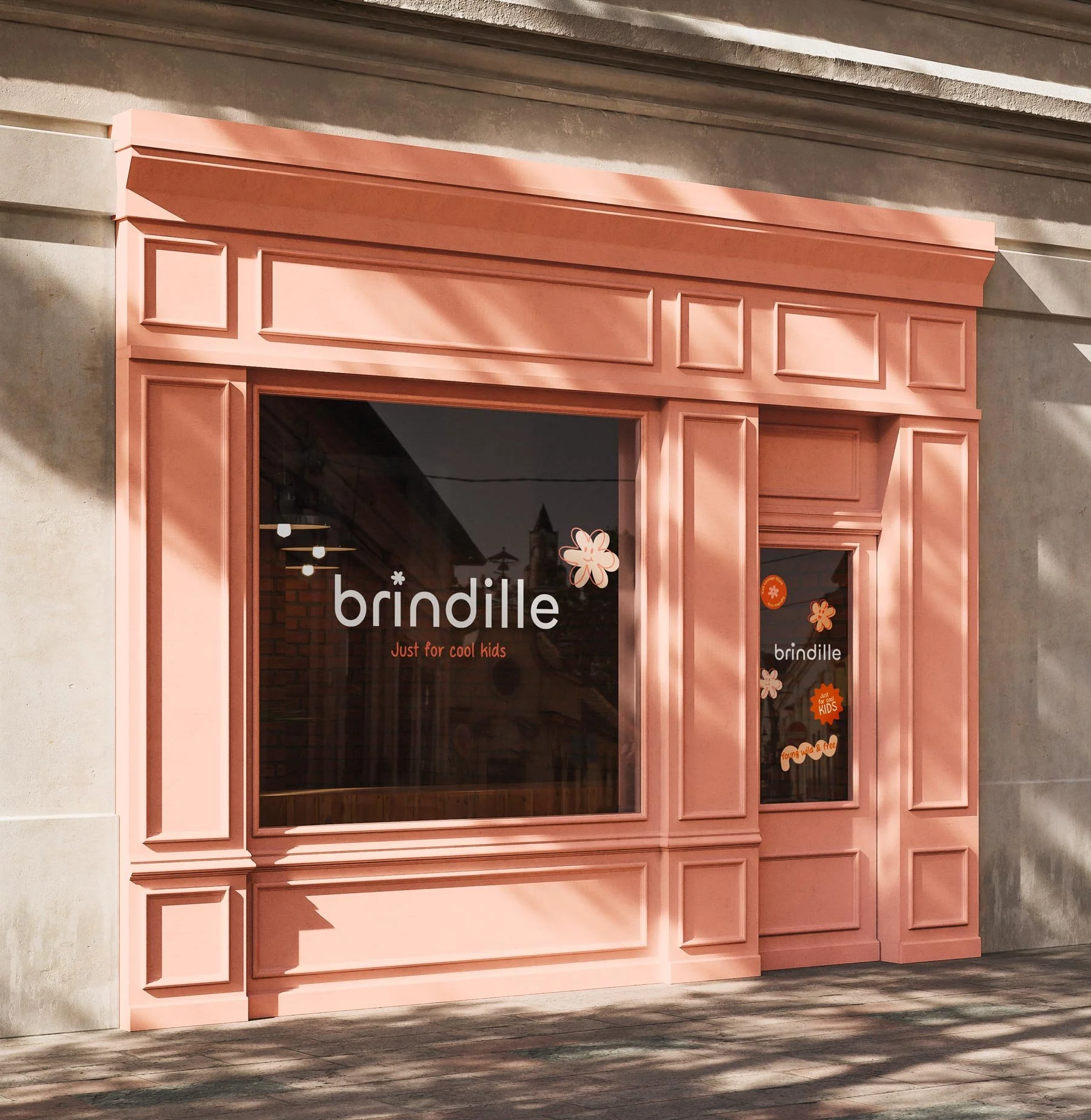 Une façade de boutique rose avec des fenêtres et une porte en bois, décorée de motifs floraux. Le nom « brindille » est affiché sur la vitre, avec la mention « Just for cool kids ».