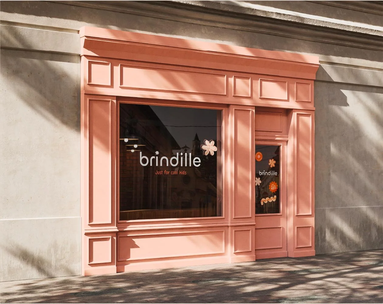 Vitrine d'un magasin nommé Brindille, des stickers floraux et colorés sur la porte d'entrée.