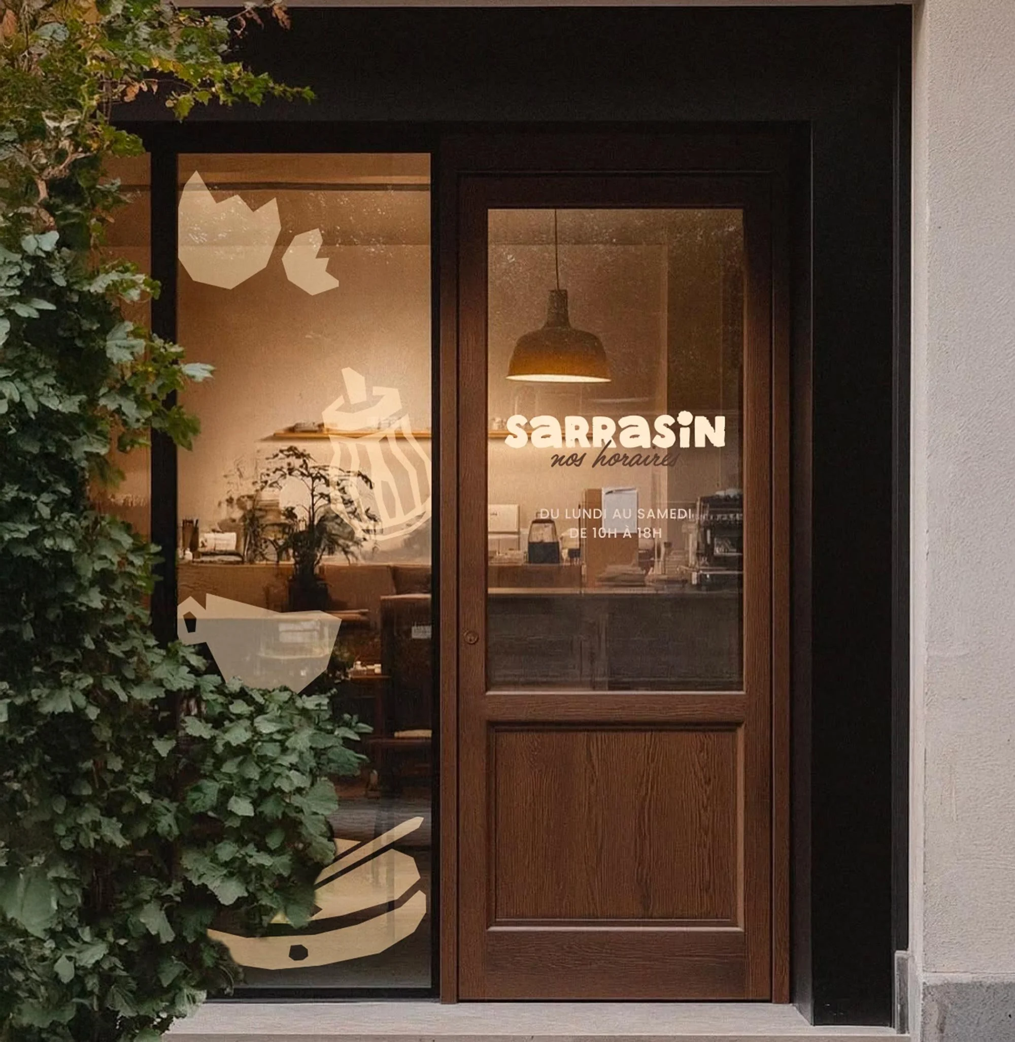 Une porte en bois avec une vitre, indiquant les horaires d'ouverture d'un commerce, avec du texte en français."Sarrasin nos horaires de lundi à samedi de 10h à 18h"