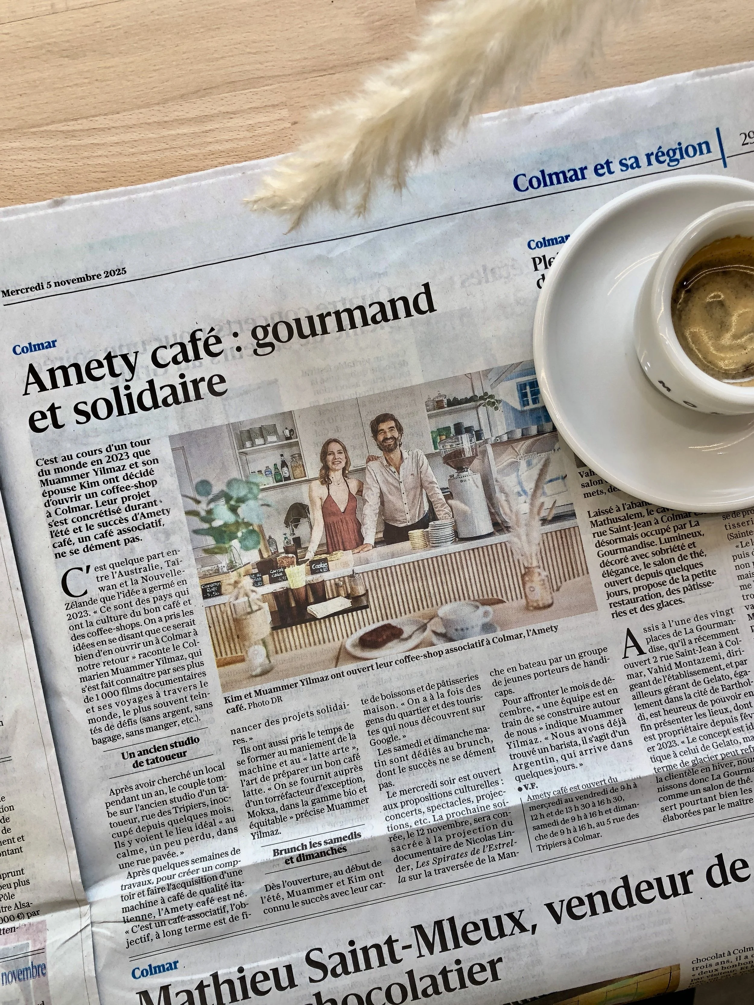 Une tasse de café sur une soucoupe, posée sur un journal.