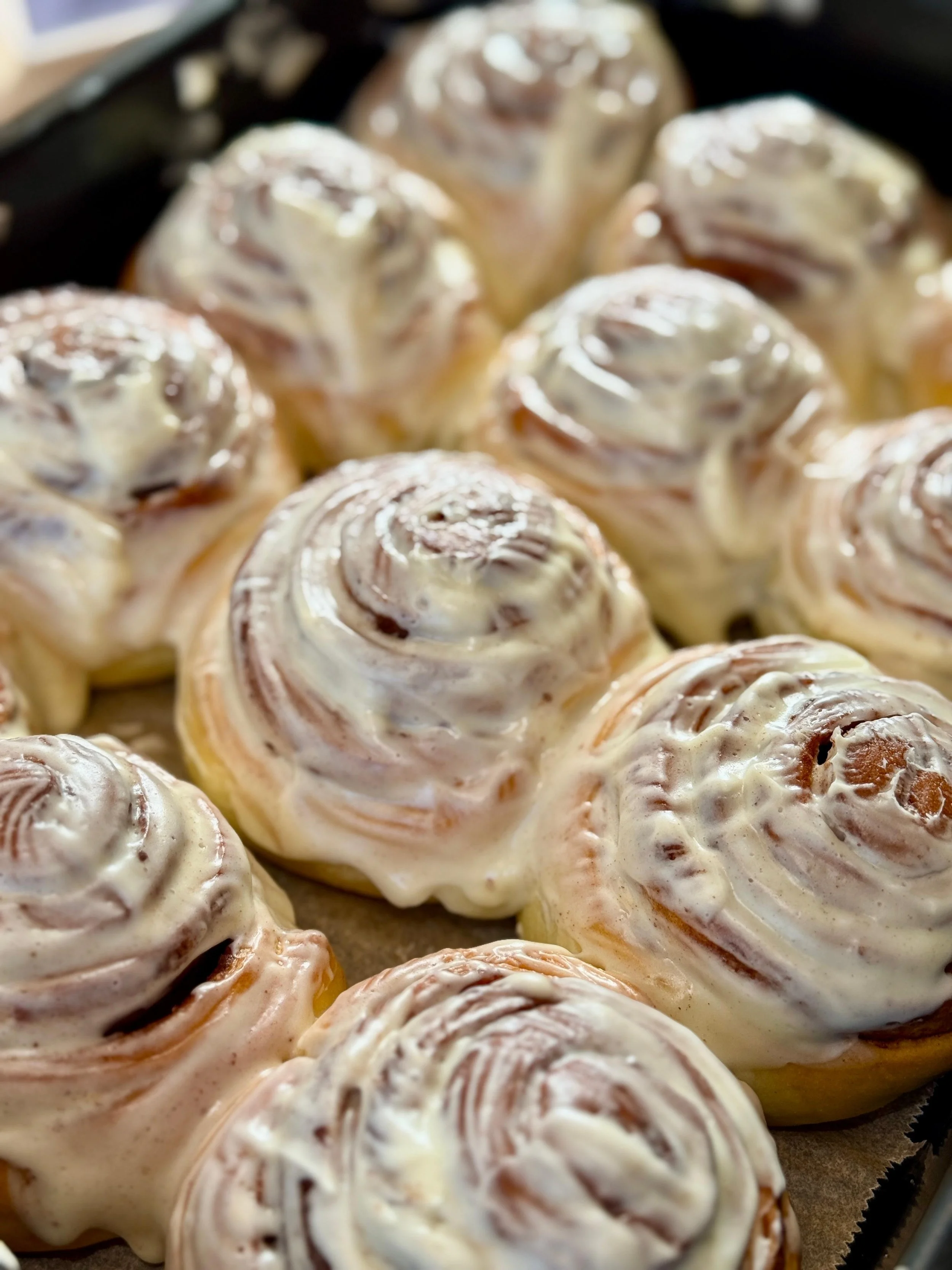 Cinnamon rolls à la cannelle recouverts de glaçage blanc.