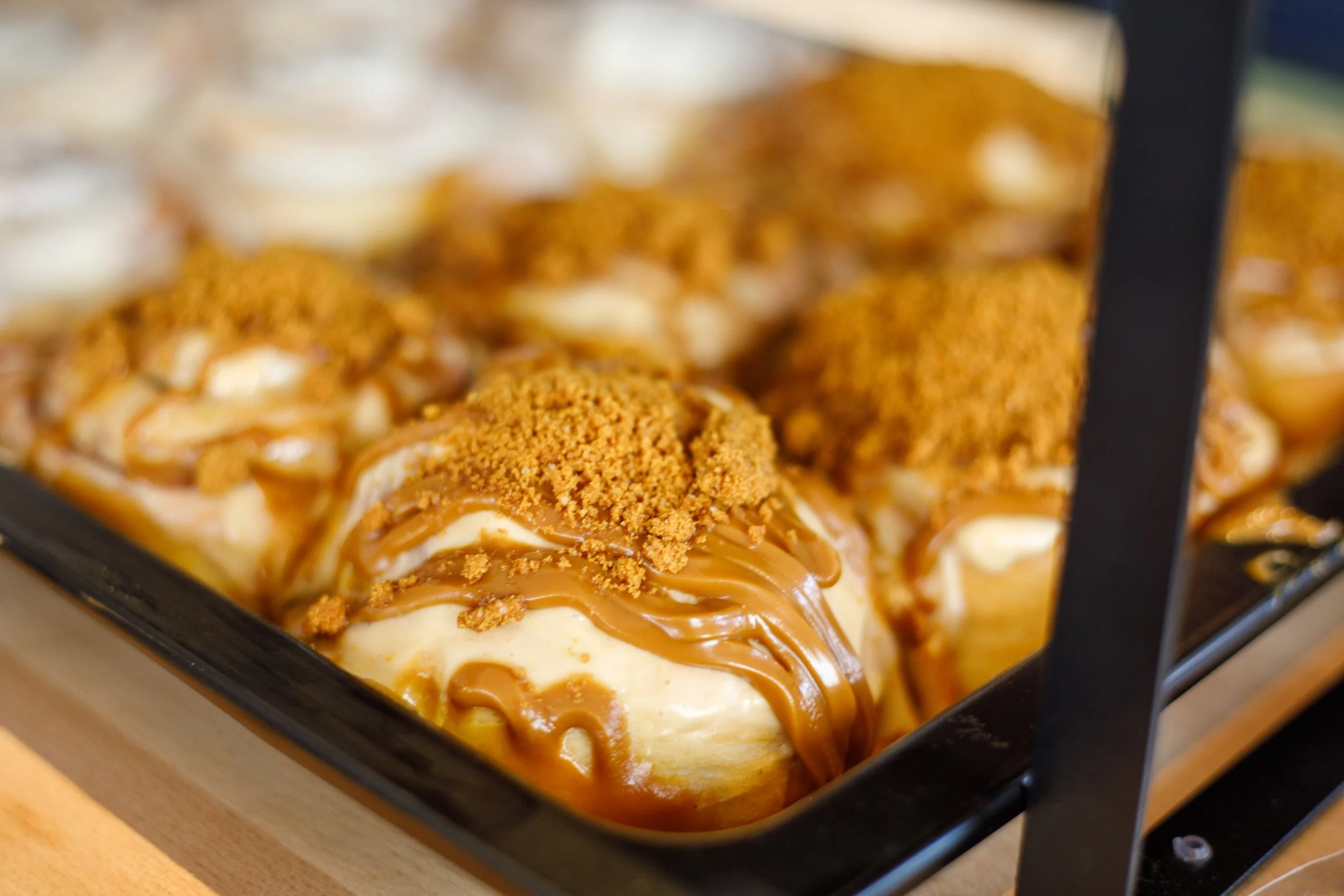 Bananes nappées de caramel avec du crumble croustillant, dans un plat noir.