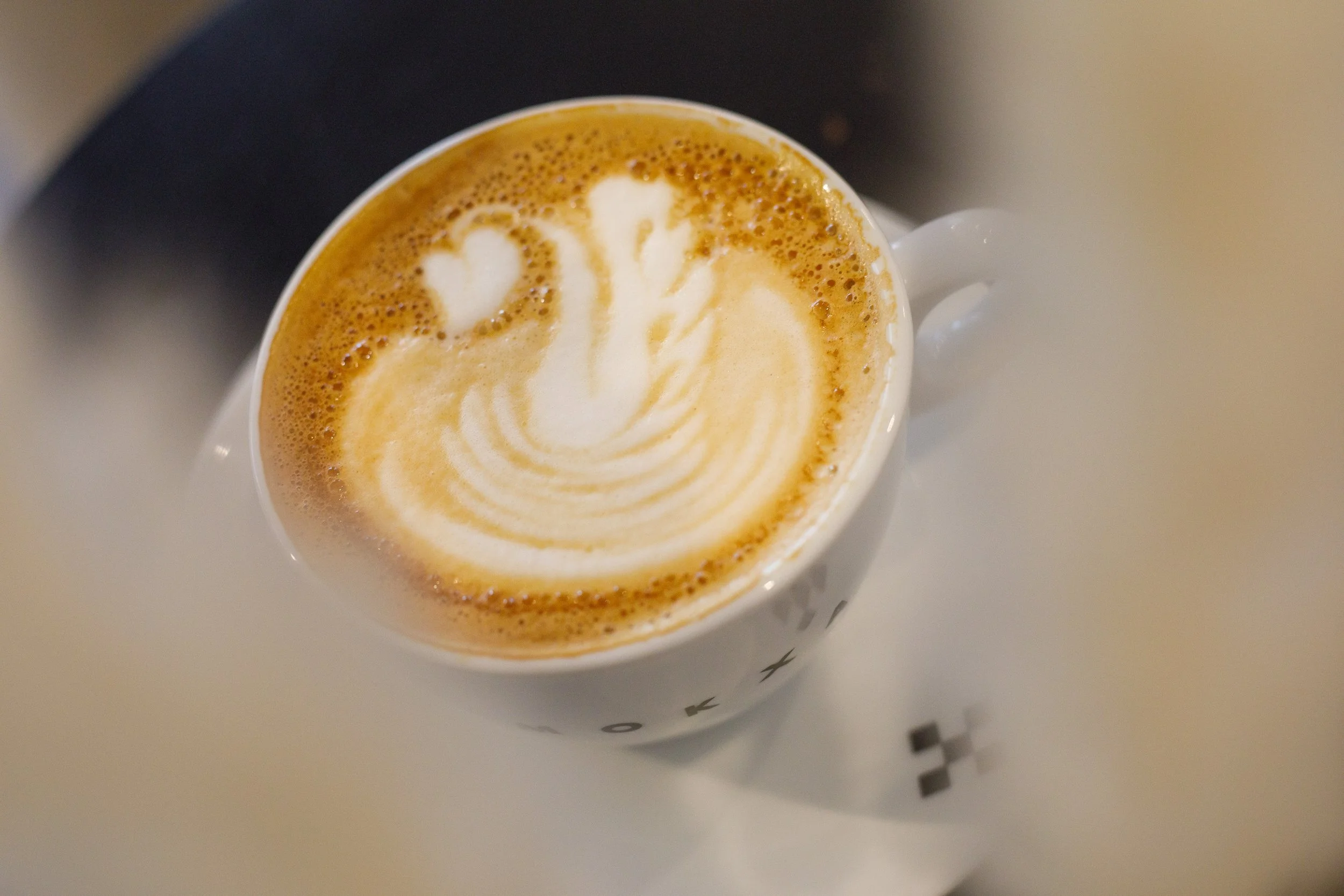 Un cappuccino dans une tasse blanche avec un dessin en lait en forme de cygne.