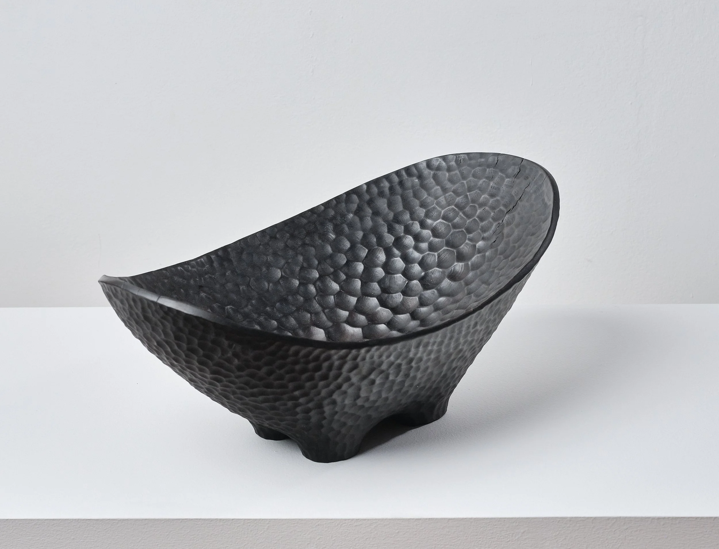 Black textured long bowl made from London Plane timber, on a white surface against a white background.