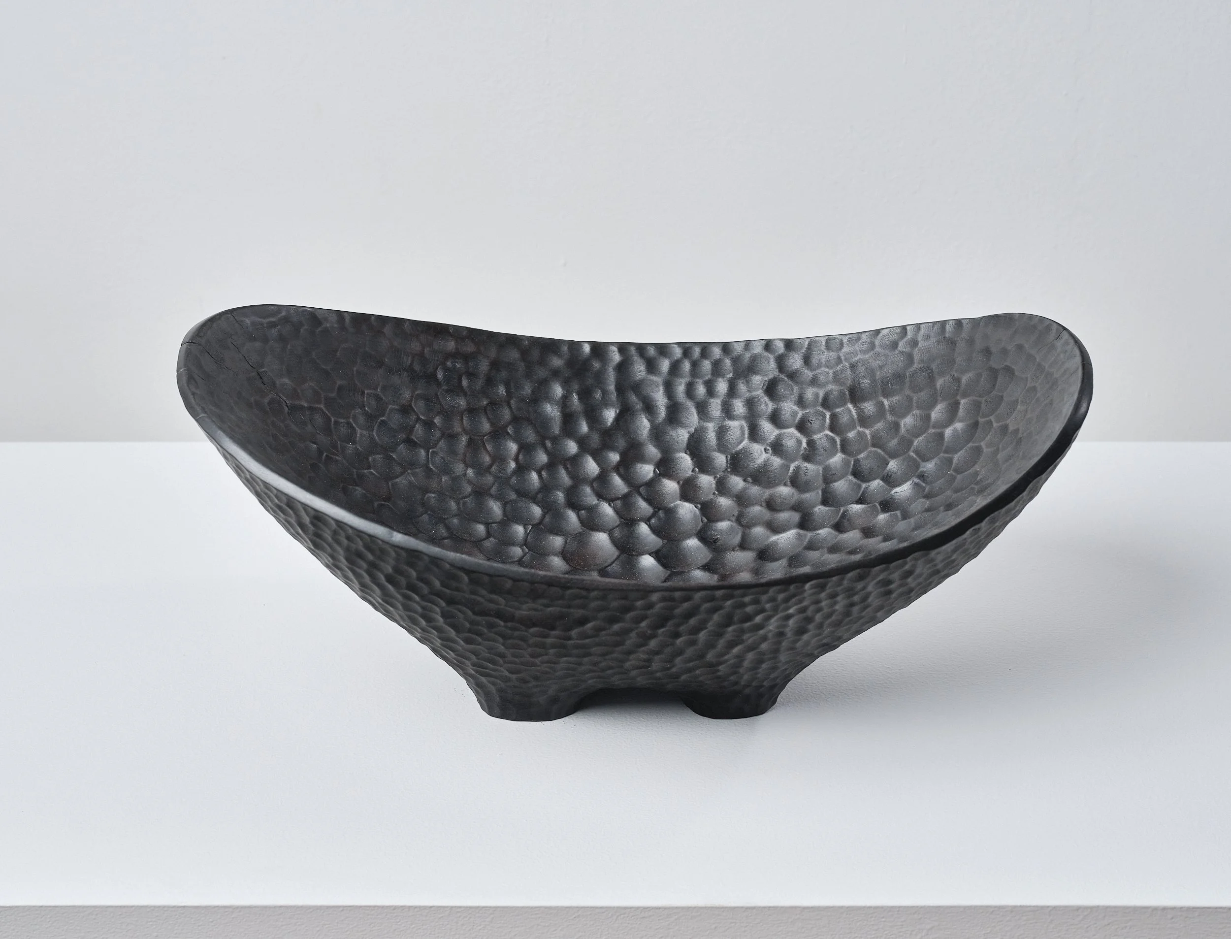 Black textured long bowl made from London Plane timber, on a white surface against a white background.