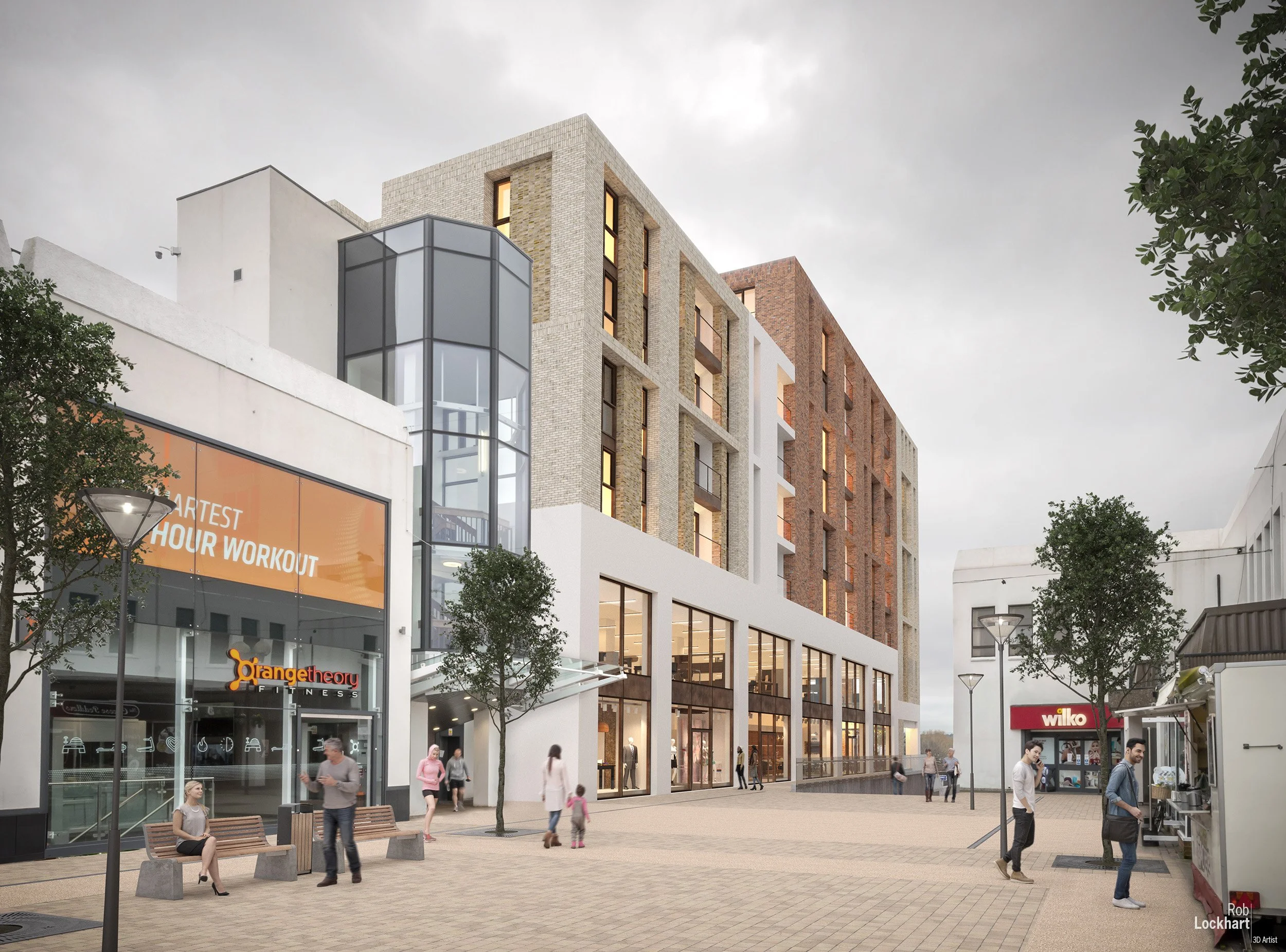 A modern shopping complex with retail stores, including a fitness center called Orange Theory Fitness, and people walking and sitting in the plaza area outside. The buildings feature a combination of architectural styles and materials, with large win
