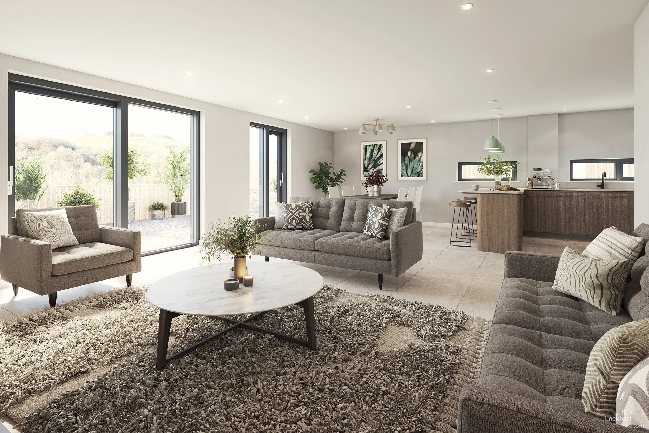 A spacious, modern living room with beige and grey sofas, a round white coffee table on a textured rug, and glass sliding doors leading to an outdoor patio with potted plants. The open-concept space includes a dining area and kitchen with bar stools,