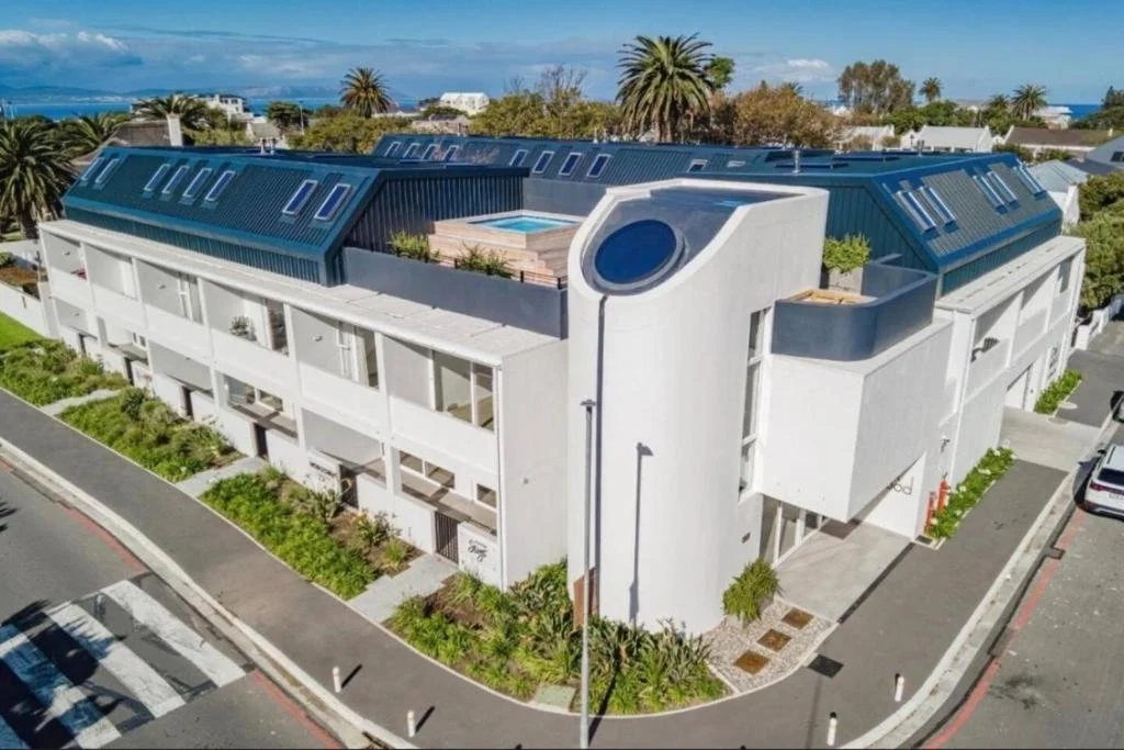 Outside of the apartment building - Oakwood apartments - Dirkie Uys Street Hermanus. Drone view showing shared rooftop pool and BBQ area.