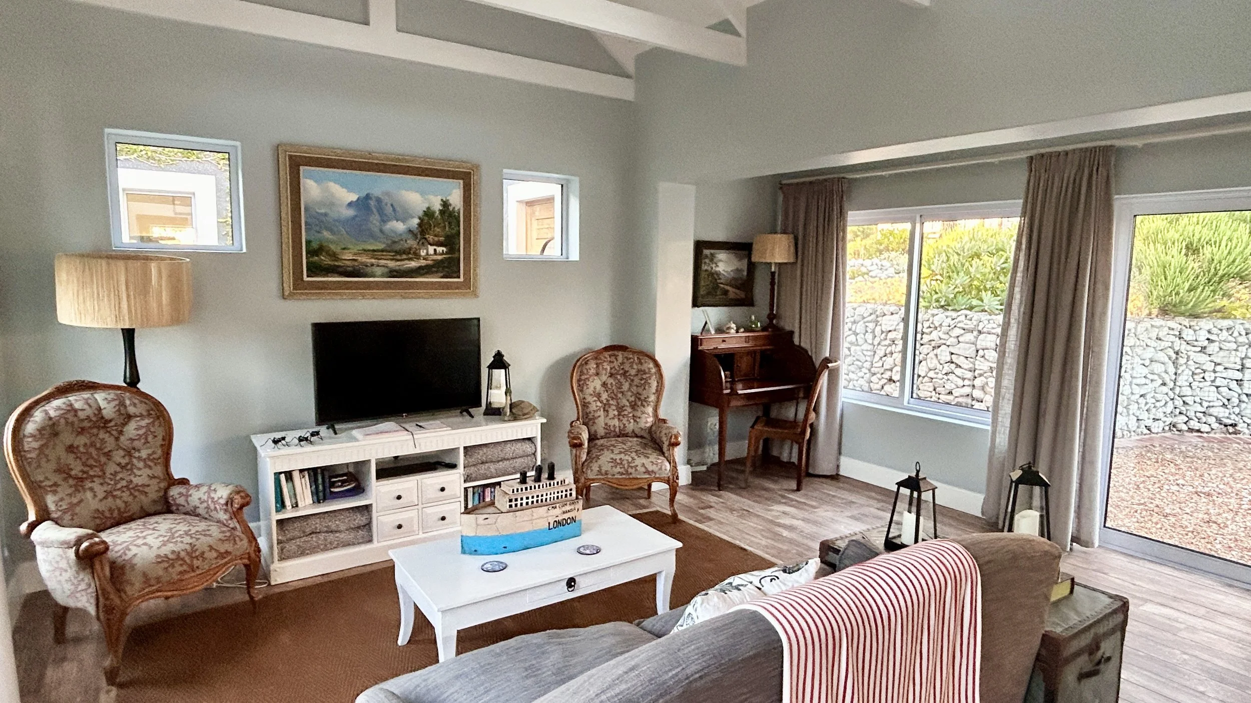 Spacious and bright lounge at Misty Shores Cottage with beautiful views of the Kogelberg Mountain and rich fynbos garden.