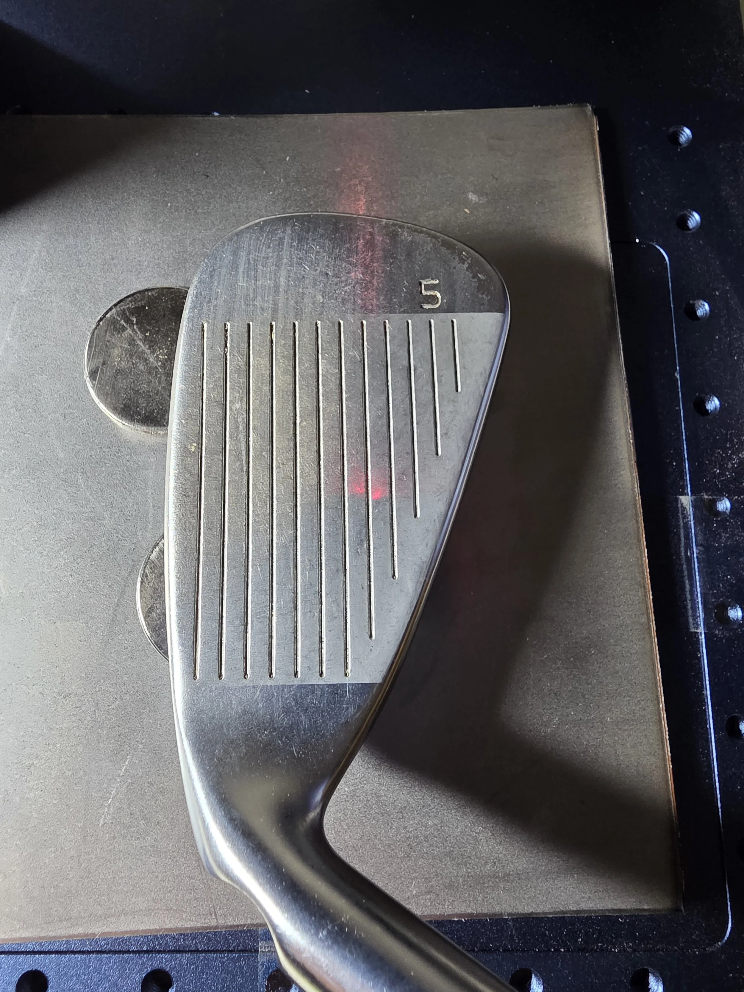 Close-up of a golf club iron that was resurfaced with a fiber laser