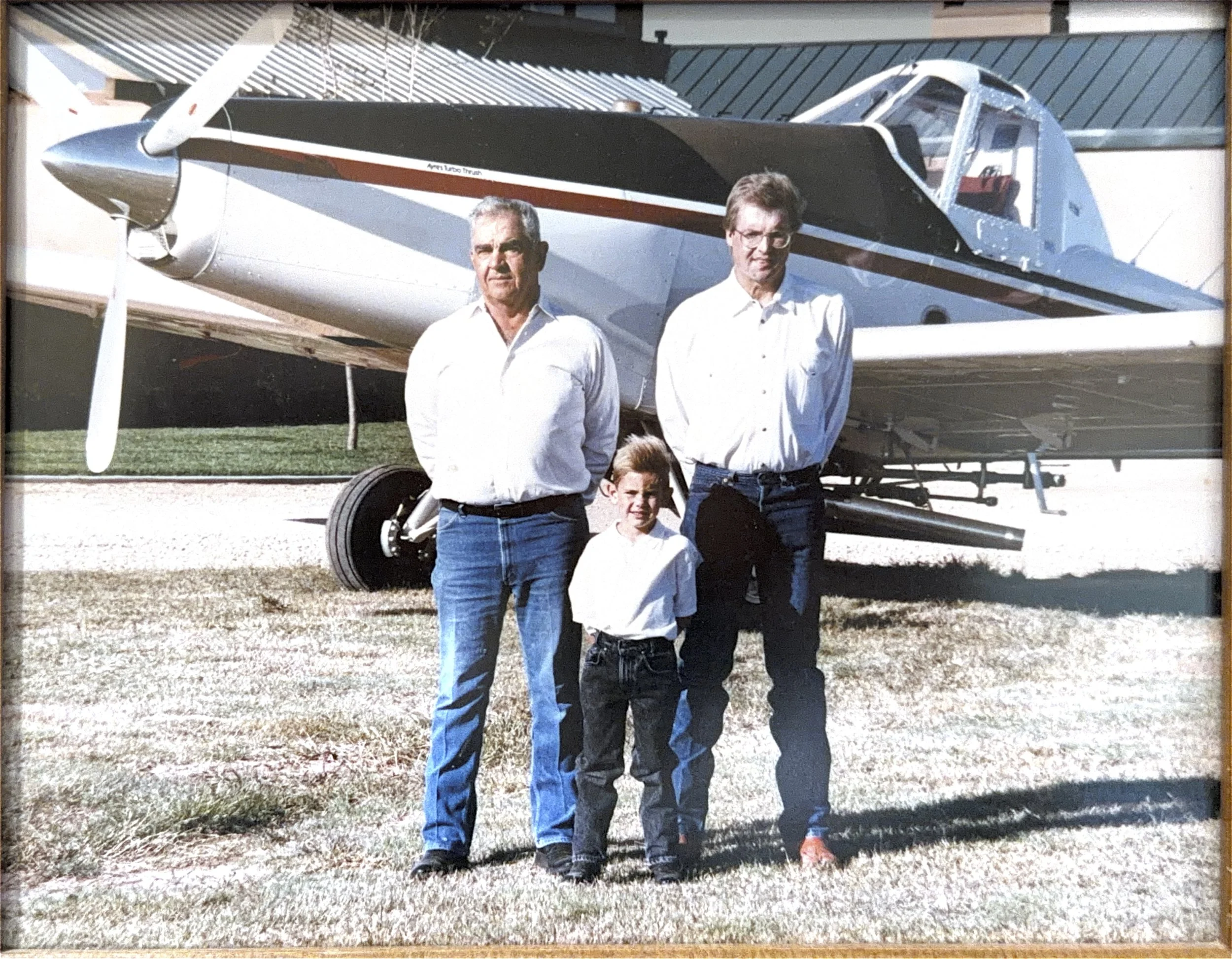 Chuck Stallings, Cameron Stallings, Ted Stallings, in front of a fixed wing aircraft.