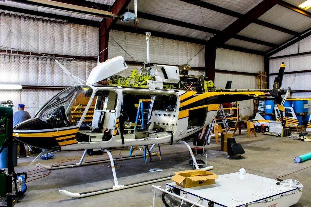 Helicopter inside a maintenance hangar for aircraft inspection, repair, and aviation support services.