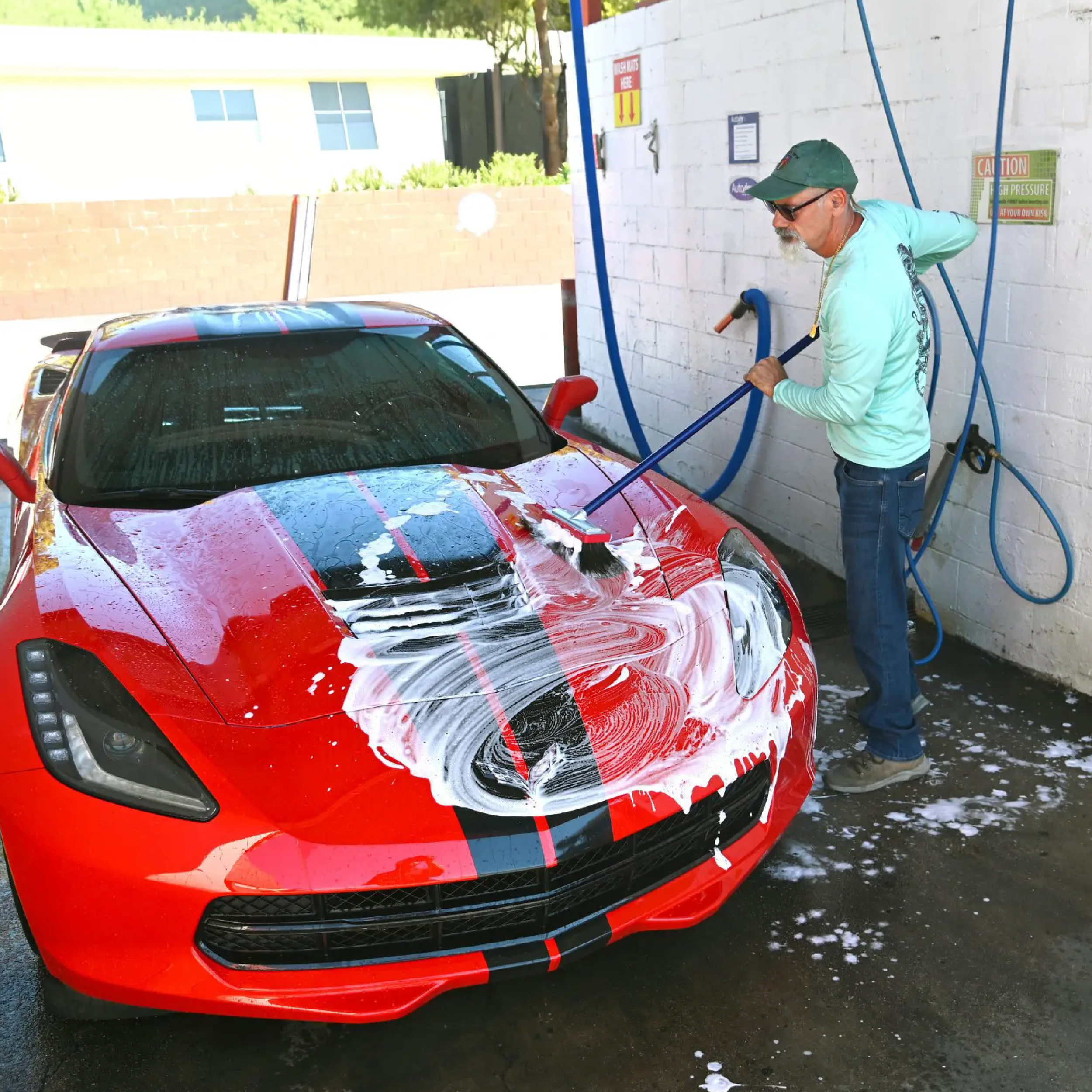 Man washing car in self serve bay