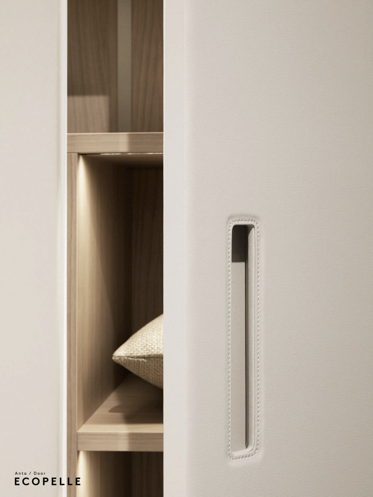 A partially opened white sliding door revealing a wooden shelf with a beige cushion inside.