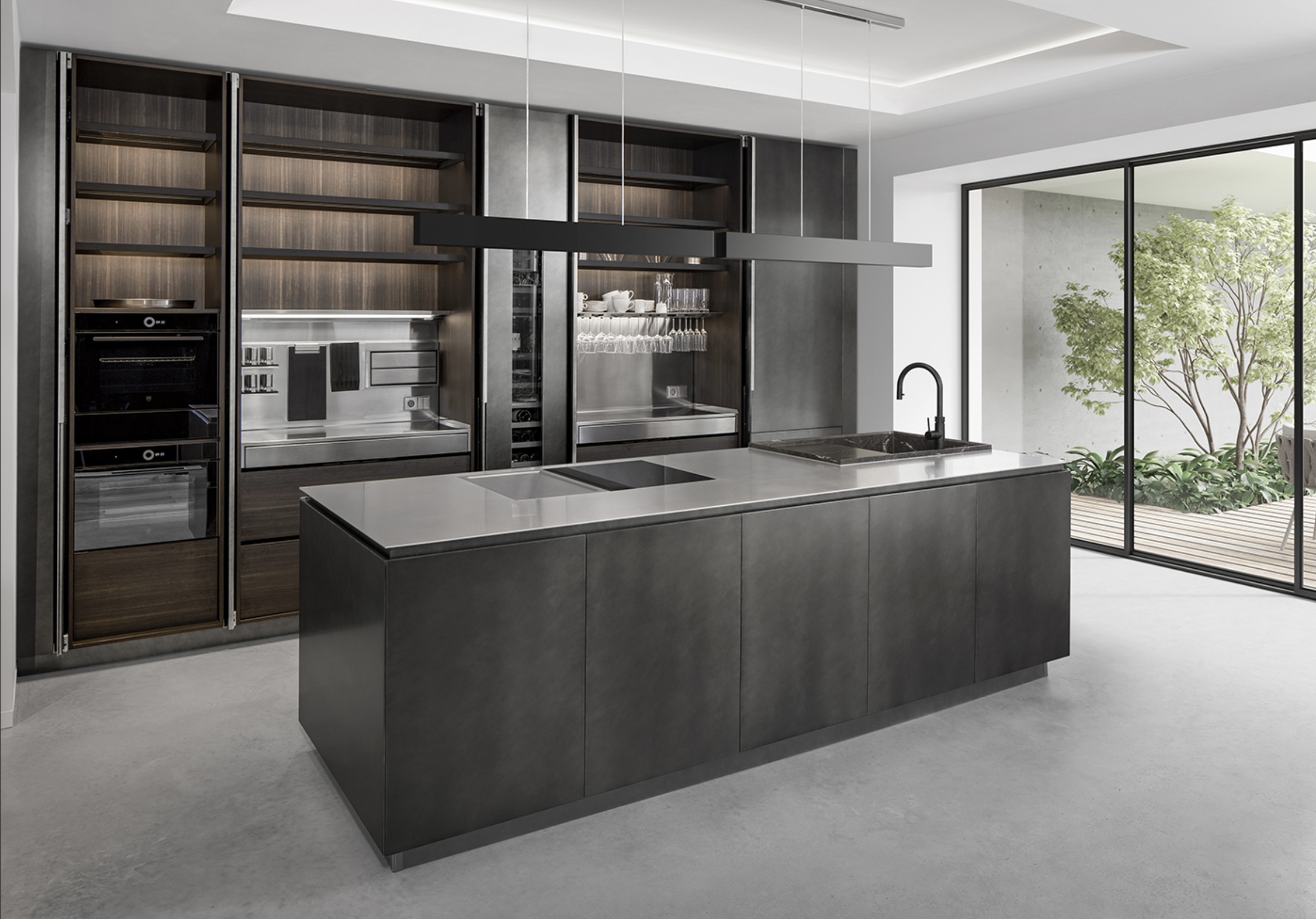 Modern kitchen with dark cabinets, stainless steel appliances, and a large island with a black sink, surrounded by floor-to-ceiling windows that open to a garden.