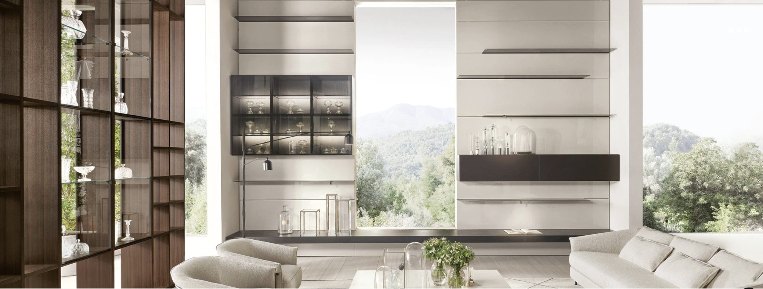Modern living room with large window overlooking mountains, beige sofas, and contemporary shelving with glassware.