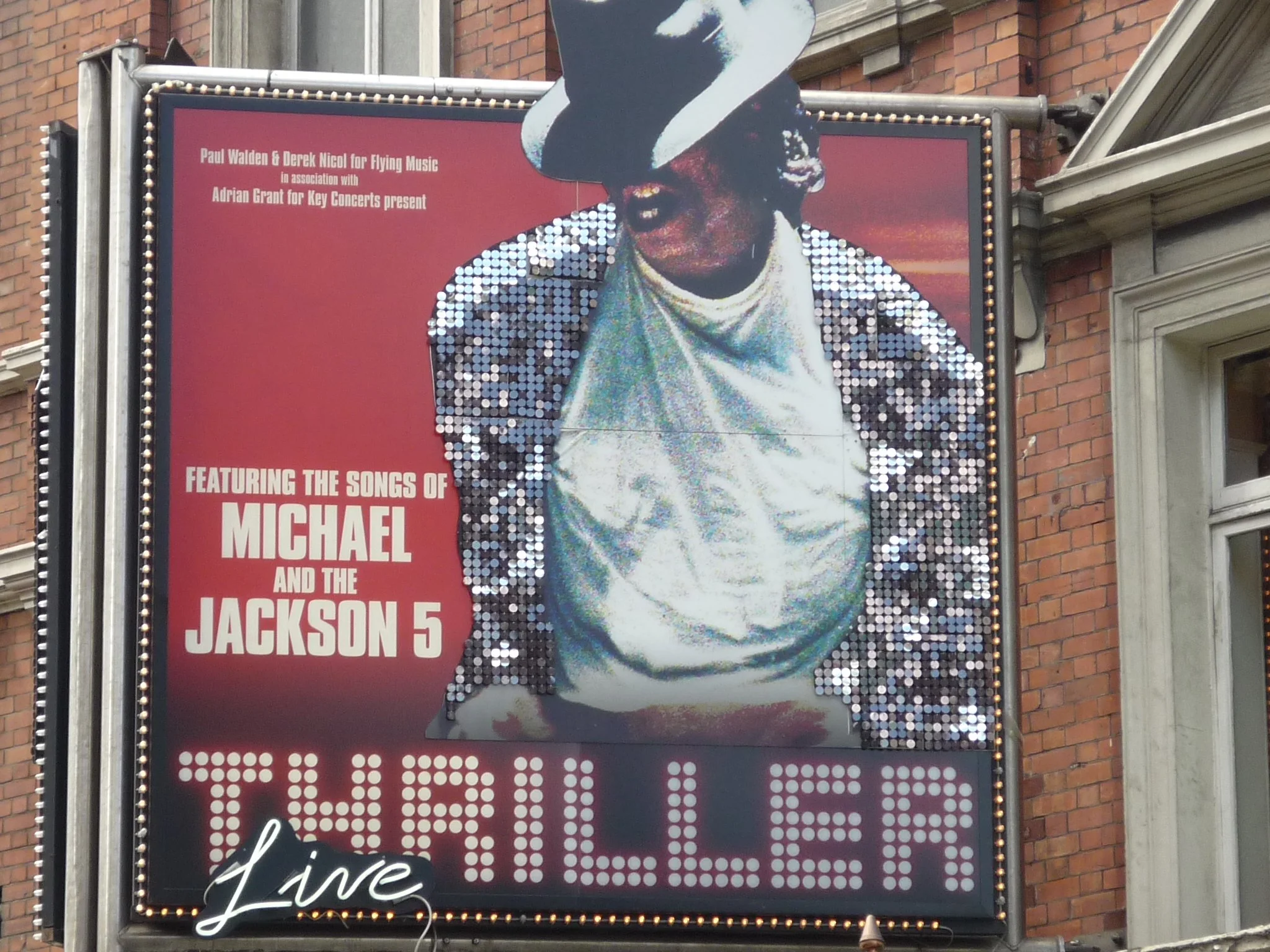 Plakat für eine Veranstaltung mit Michael Jackson und den Jackson 5, zeigt Michael Jackson in einem Paillettenanzug und Hut vor einem roten Hintergrund.
