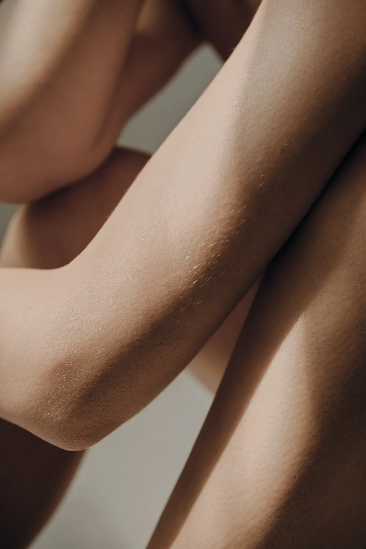 Close-up of a person's arm and shoulder with smooth skin and some fine body hair.