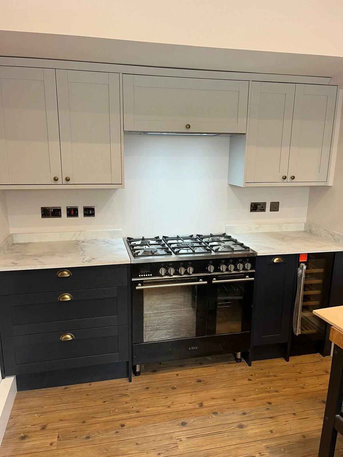 Modern shaker-style kitchen renovation with stone-effect worktops and upgraded electrical points.