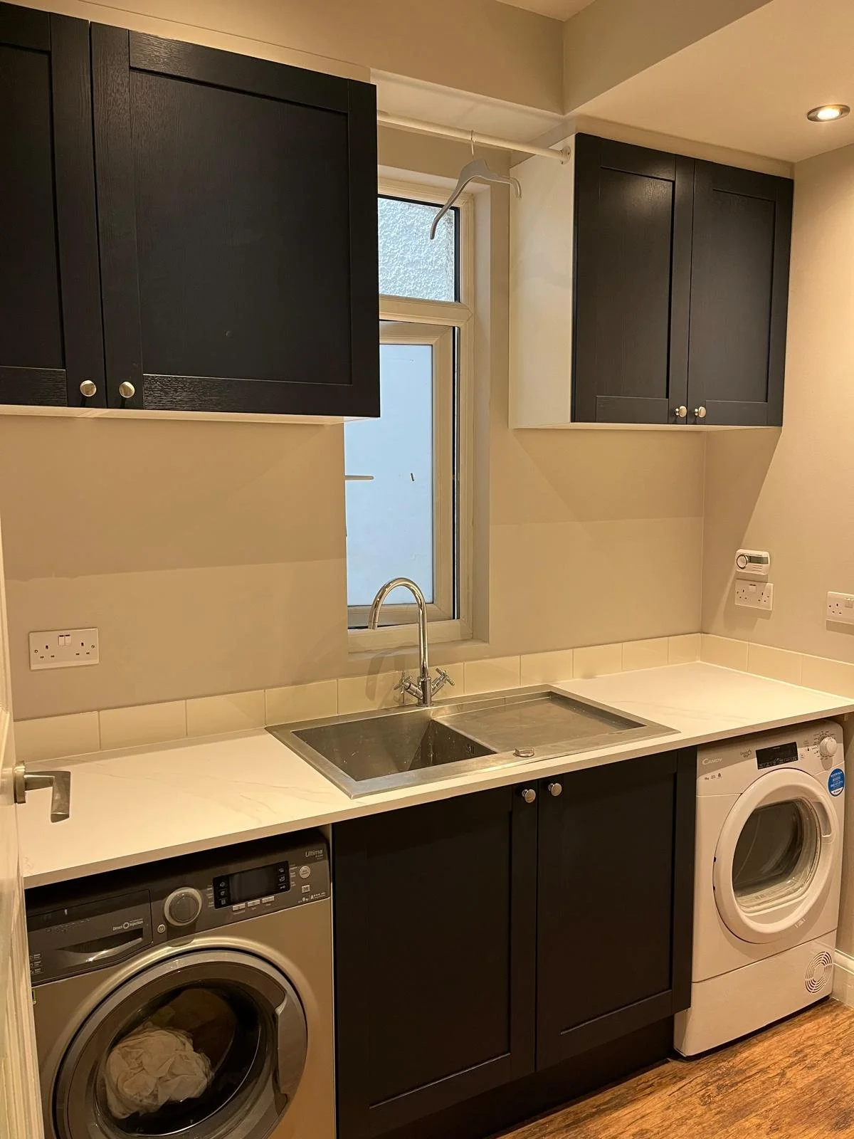 Custom Shaker-style utility room installation with practical storage solutions.