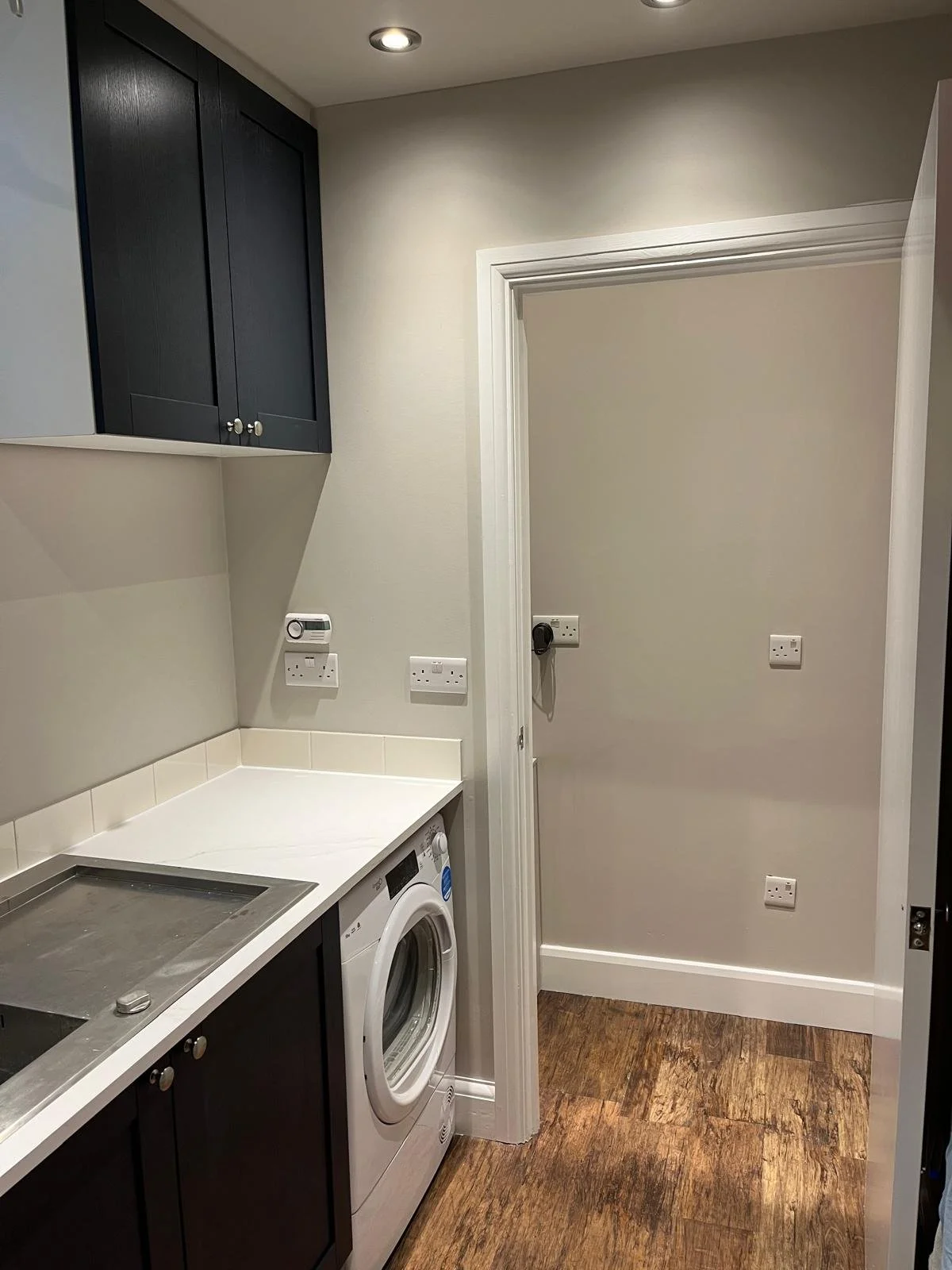 Custom Shaker-style utility room installation with practical storage solutions.