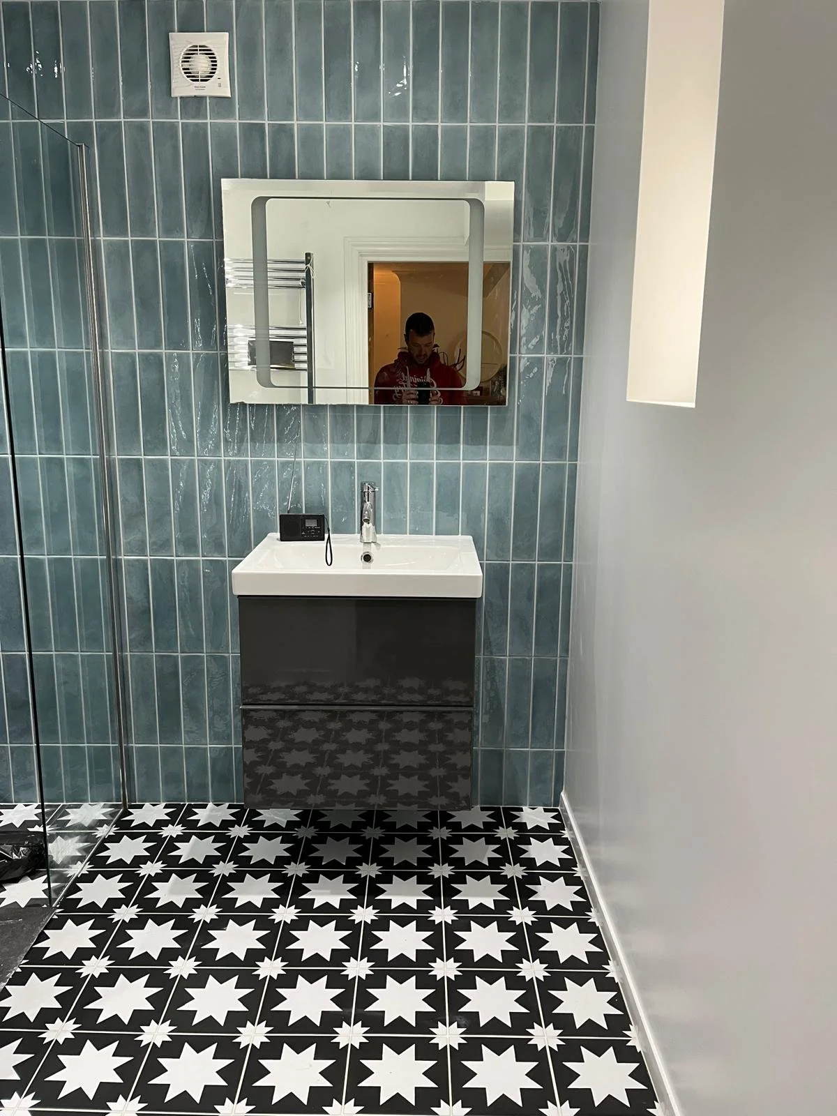 Bathroom renovation featuring a modern vanity unit and extractor fan for improved ventilation.