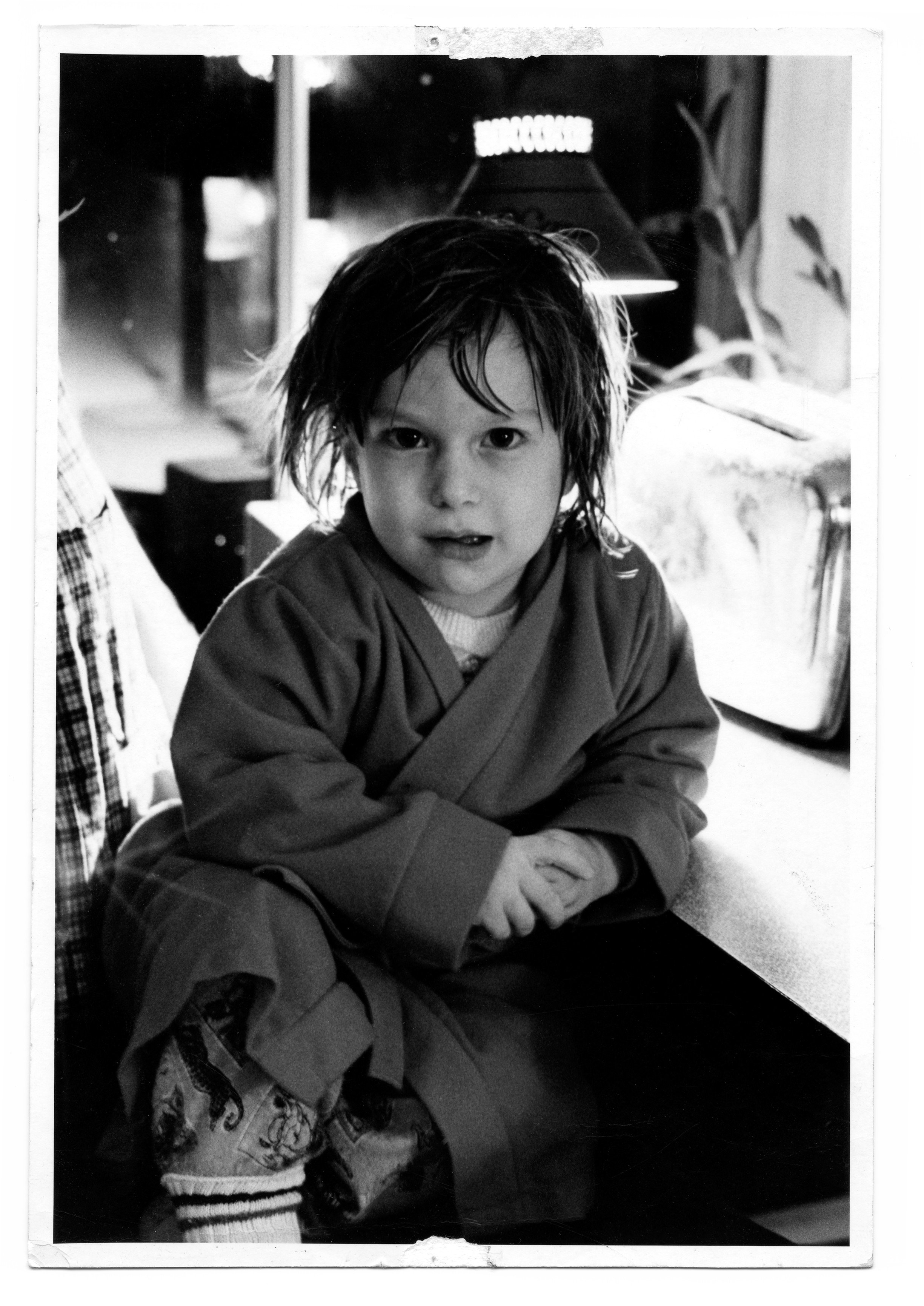 young julian schlaver sitting in robe in the kitchen