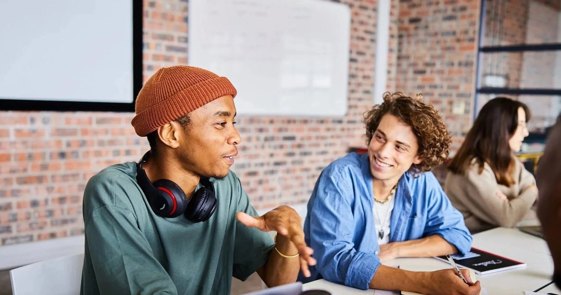 Students discussing course material together at a table during a collaborative training session