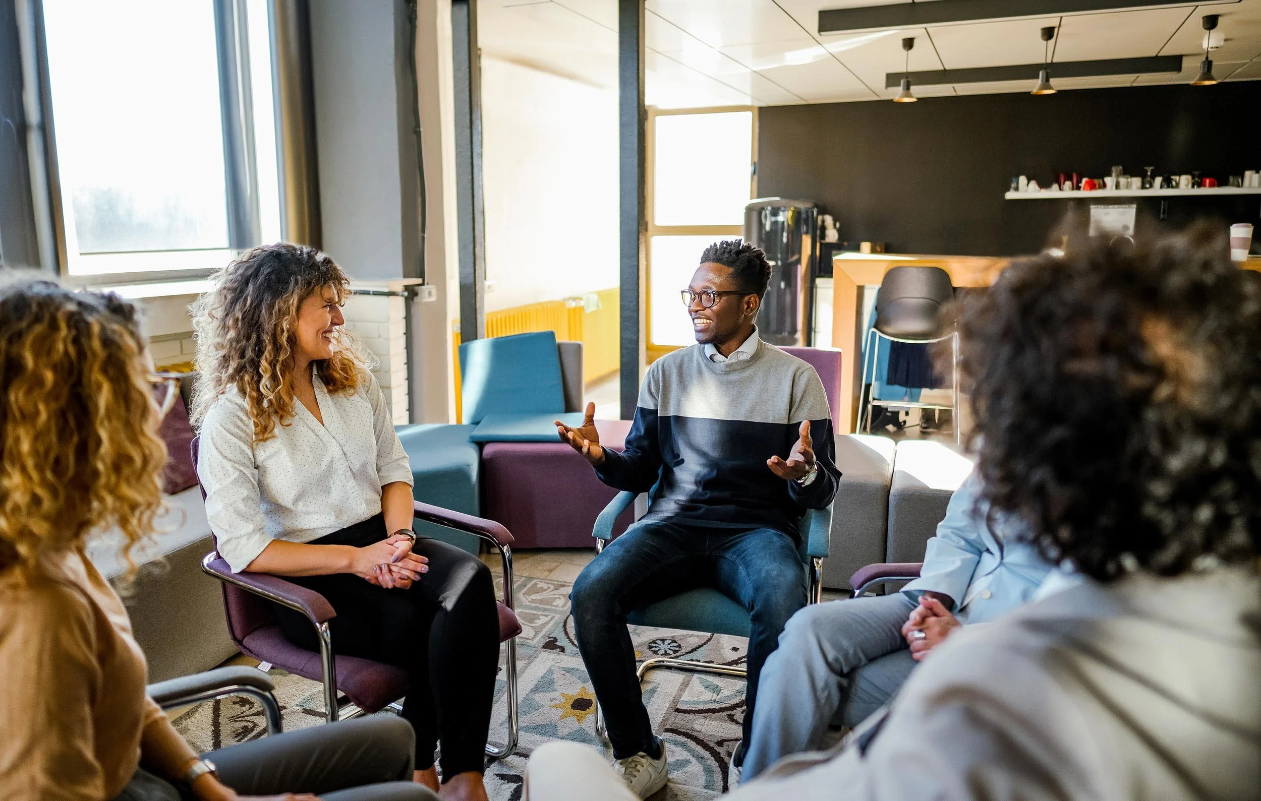 Small group of professionals engaged in an interactive learning discussion seated in a circle