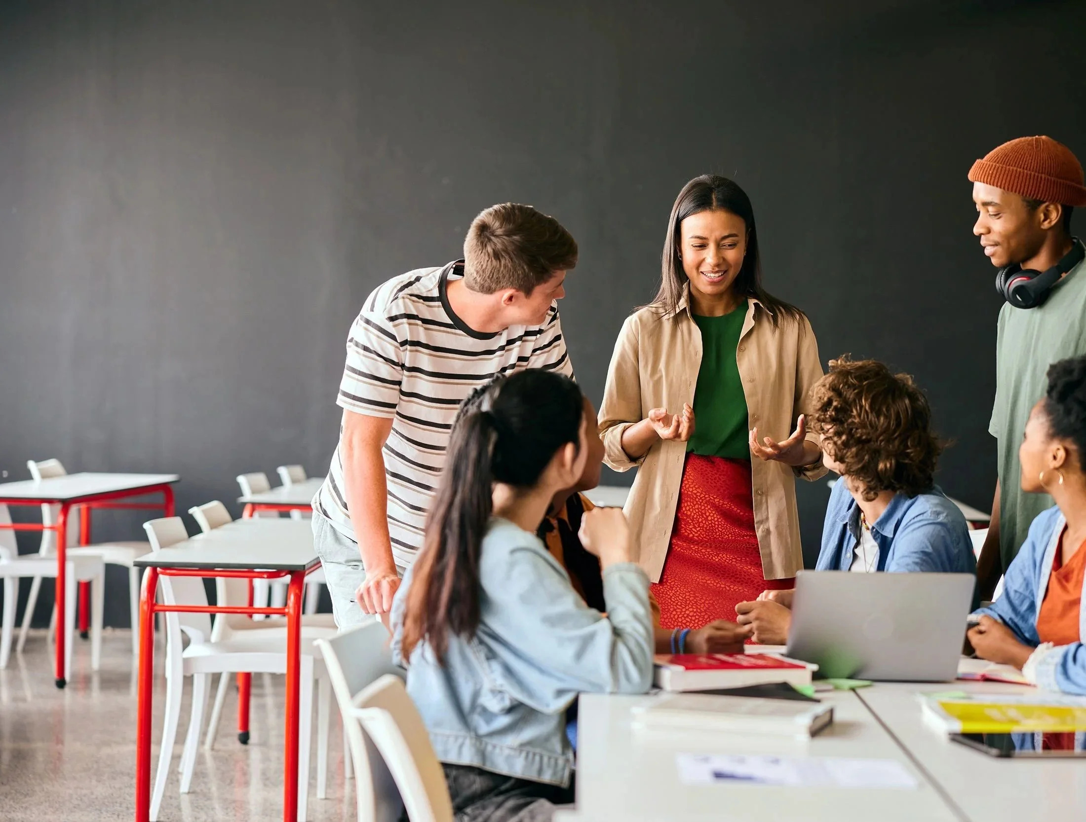 Insurance trainer explaining concepts to a diverse group of students during an interactive classroom training session