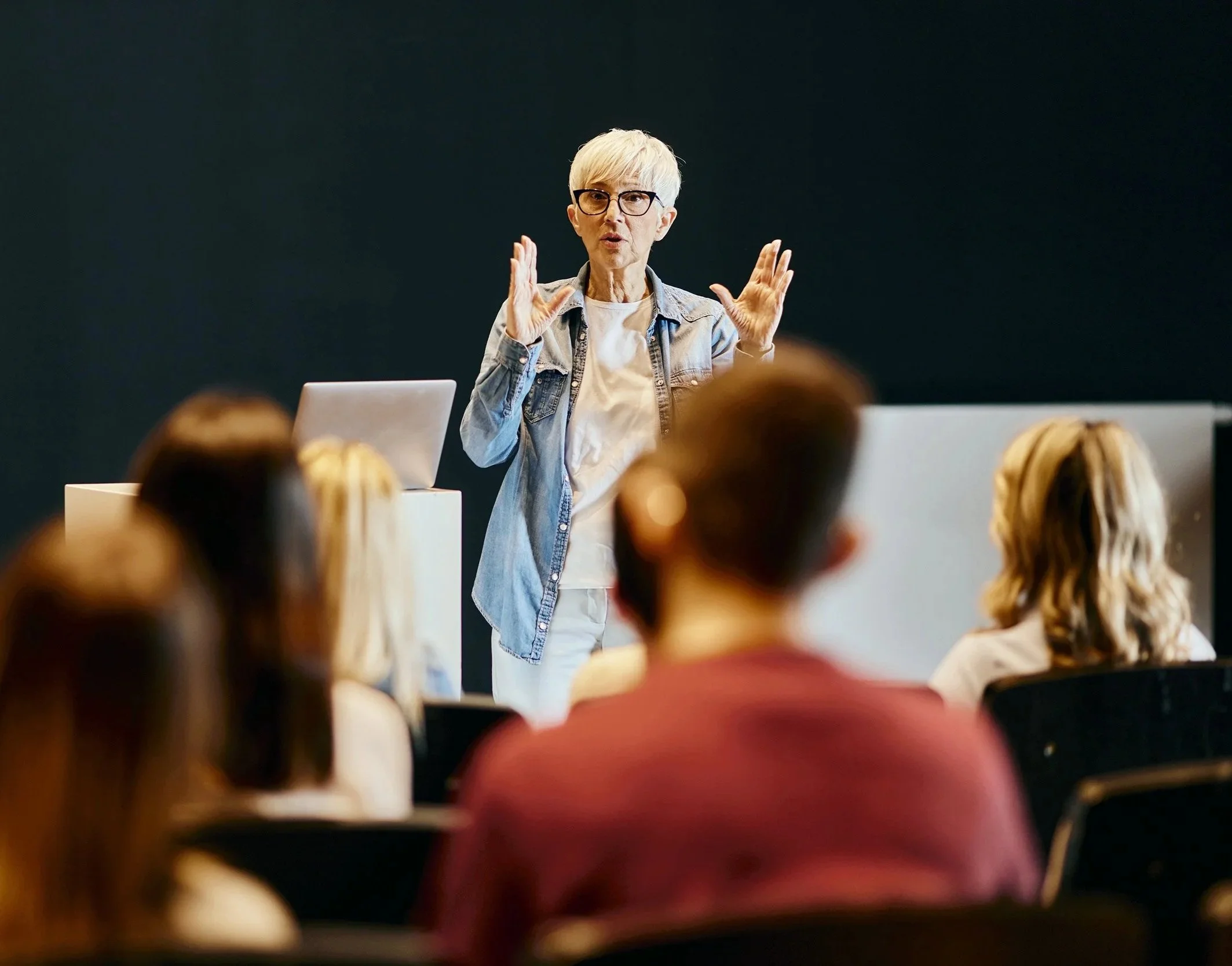 An instructor delivering a training session to a seated audience in a classroom setting