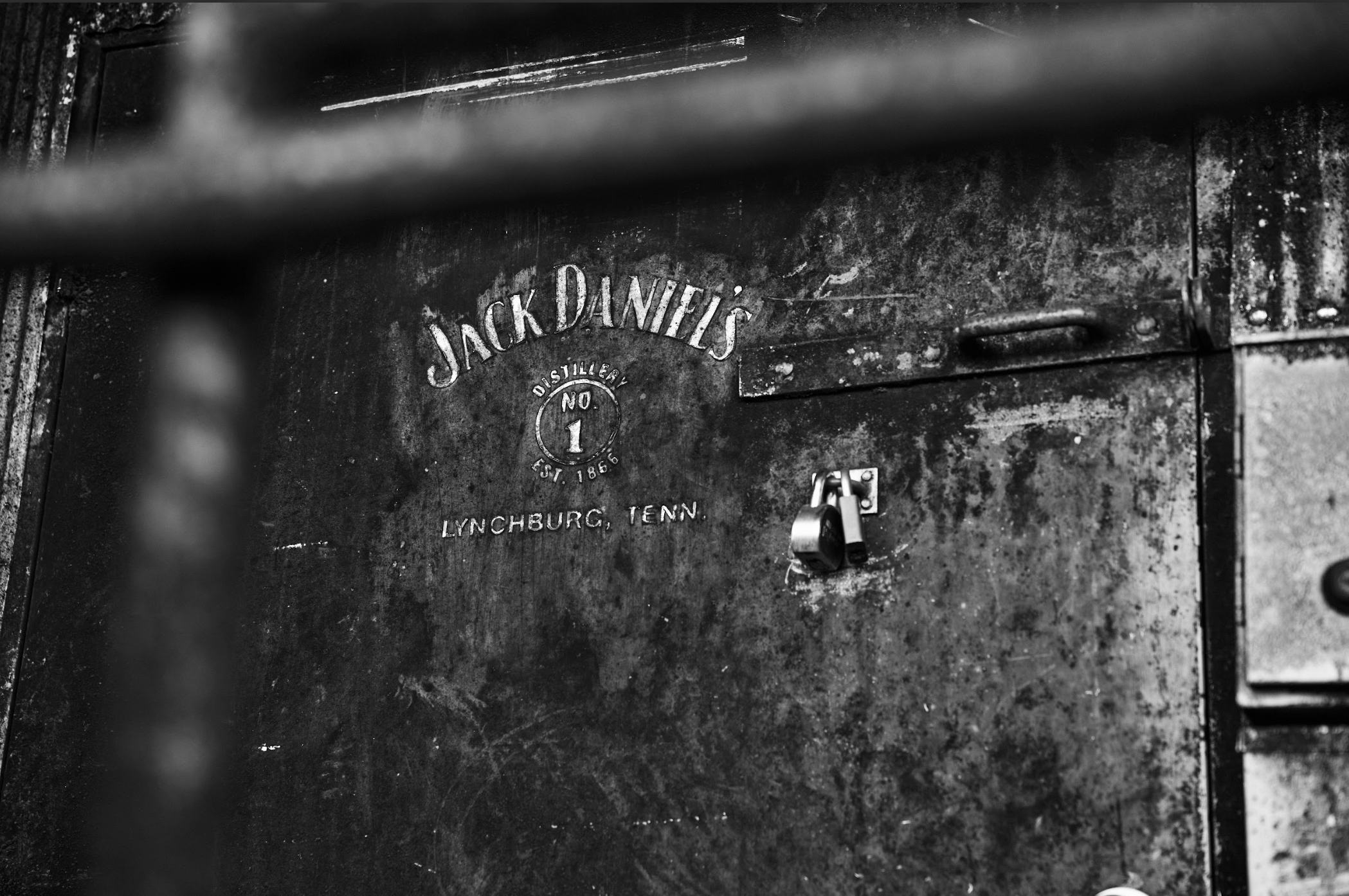 Close-up of a vintage metal locker with a padlock, branded with the Jack Daniel's distillery logo, indicating Lynchburg, Tennessee.