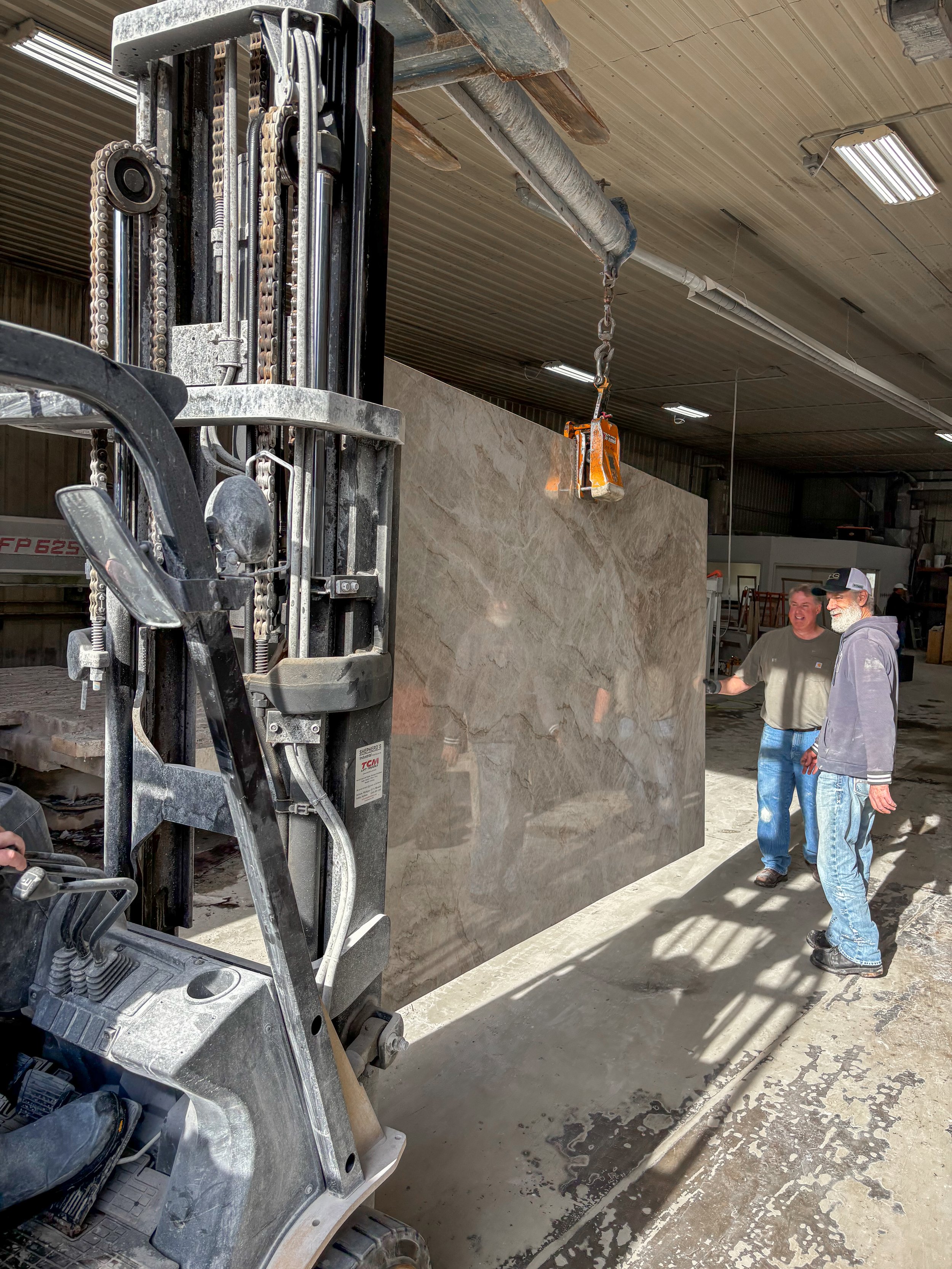 Stonecrafters fabrication team with a large polished stone slab – expert countertop and surface installation