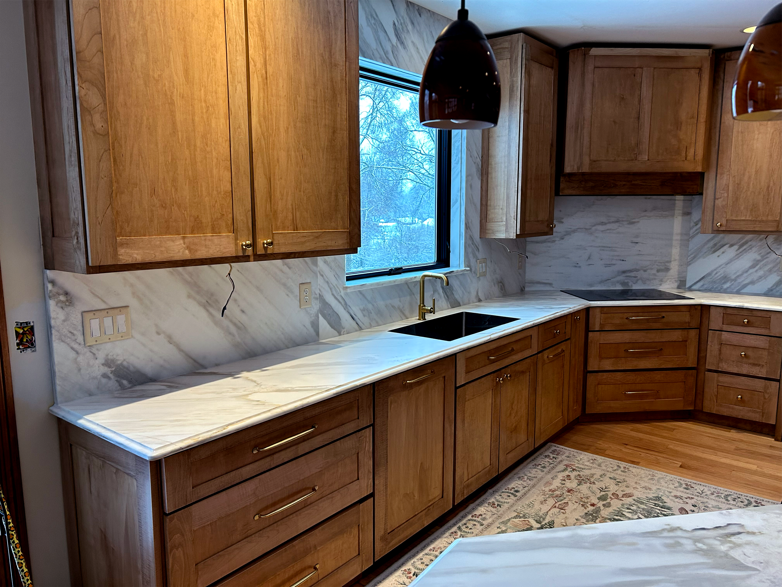 Stonecrafters marble countertops and sink in a kitchen with wooden cabinets