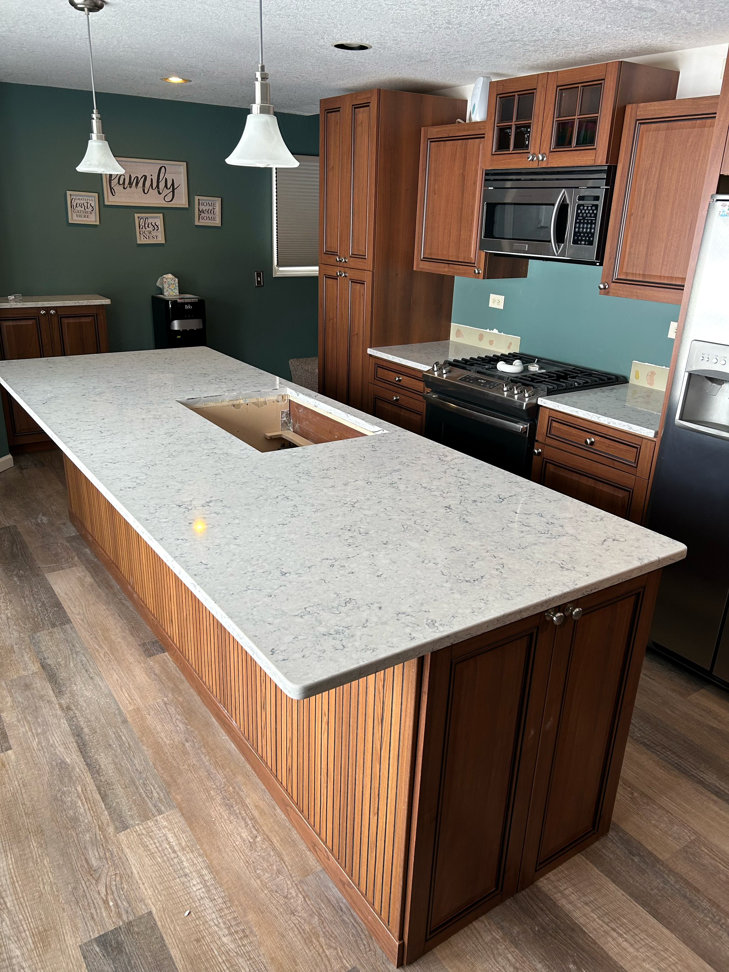 Stonecrafters custom granite countertops and large kitchen island with wooden cabinetry