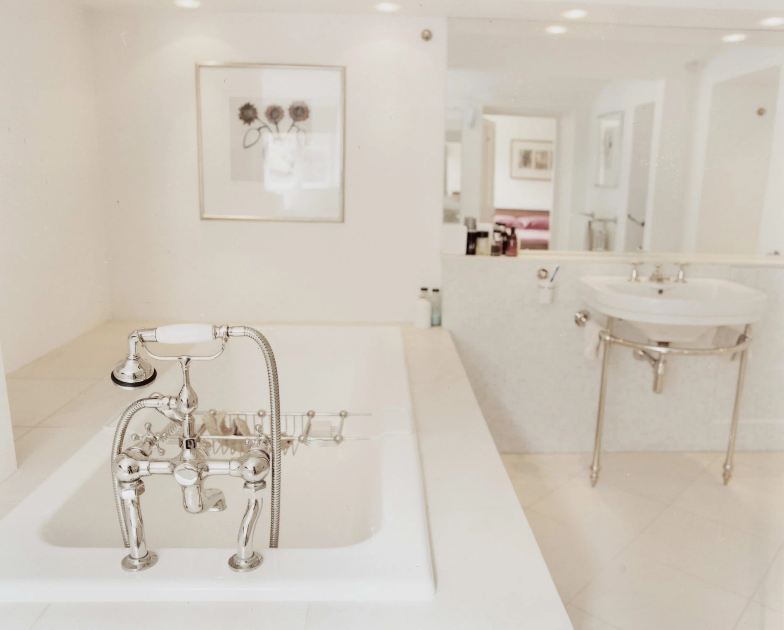 A luxury bathroom in a period building in Clifton, Bristol, with a large white bathtub, nickel plated brassware, a vanity with a sink